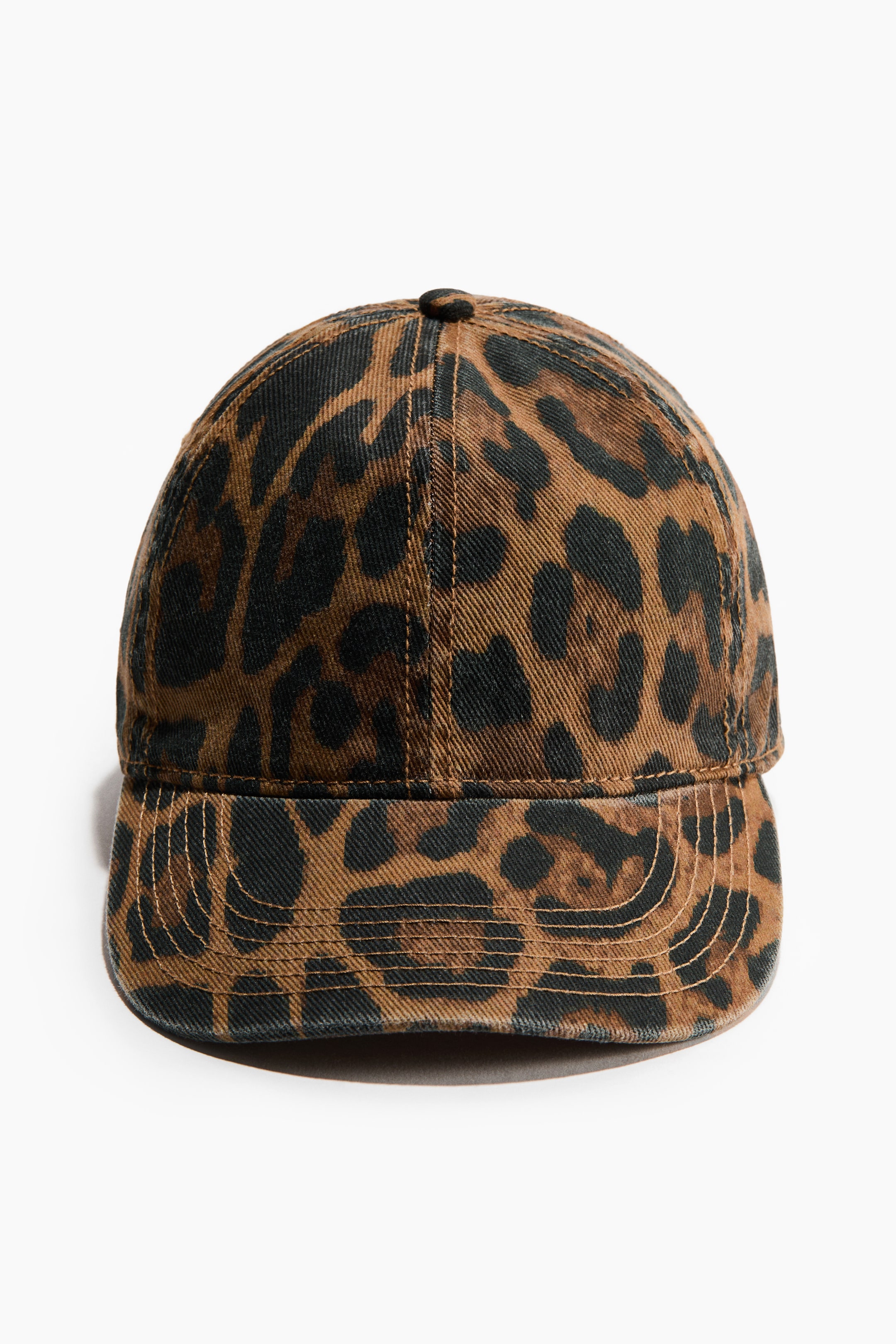 Vis større bilde: En caps er vendt fremover, med et brunt og svart leopardmønster på bomullstwillstoff med en vasket look. Den er designet med en seks-panels krone og en buet brem.