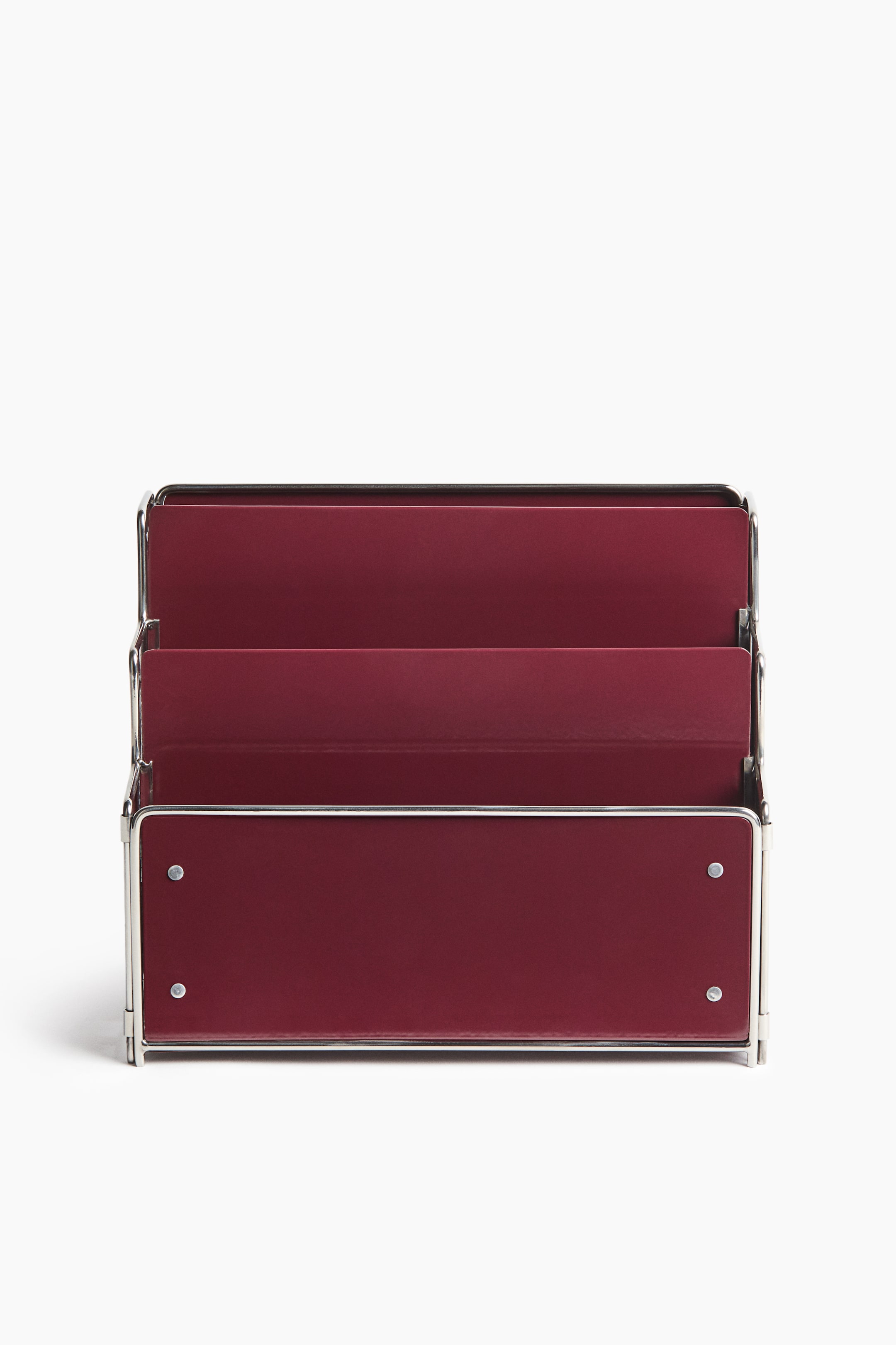 View larger image: A three-tier magazine rack is shown from a front-facing angle, featuring burgundy-red powder-coated metal panels set within a polished stainless steel frame. The structure rises in three cascading tiers, with four small silver rivets visible on the front panel.