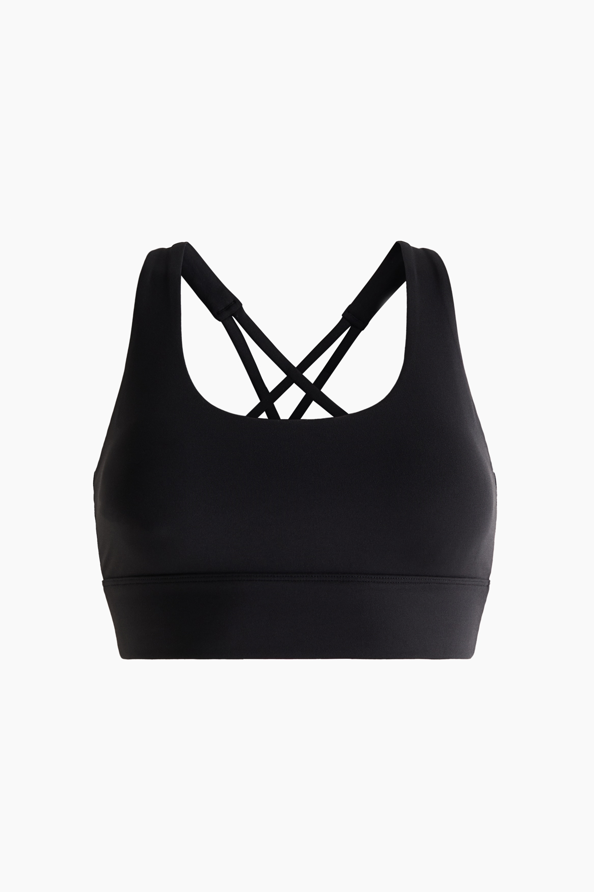 A black scoop neck sports bra is featuring wide straps and a cropped hem, pairing with matching black high-waisted leggings. Both items are showcasing a smooth, form-fitting design.