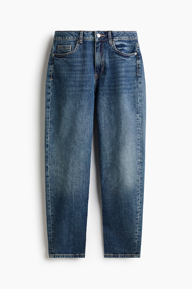 A pair of high-waisted, five-pocket blue denim jeans is shown from the front, showcasing a medium wash with subtle fading on the thighs. The legs are tapering slightly toward the hems, and the design is completed with a waistband with belt loops, a top button, and a zip fly. - 1
