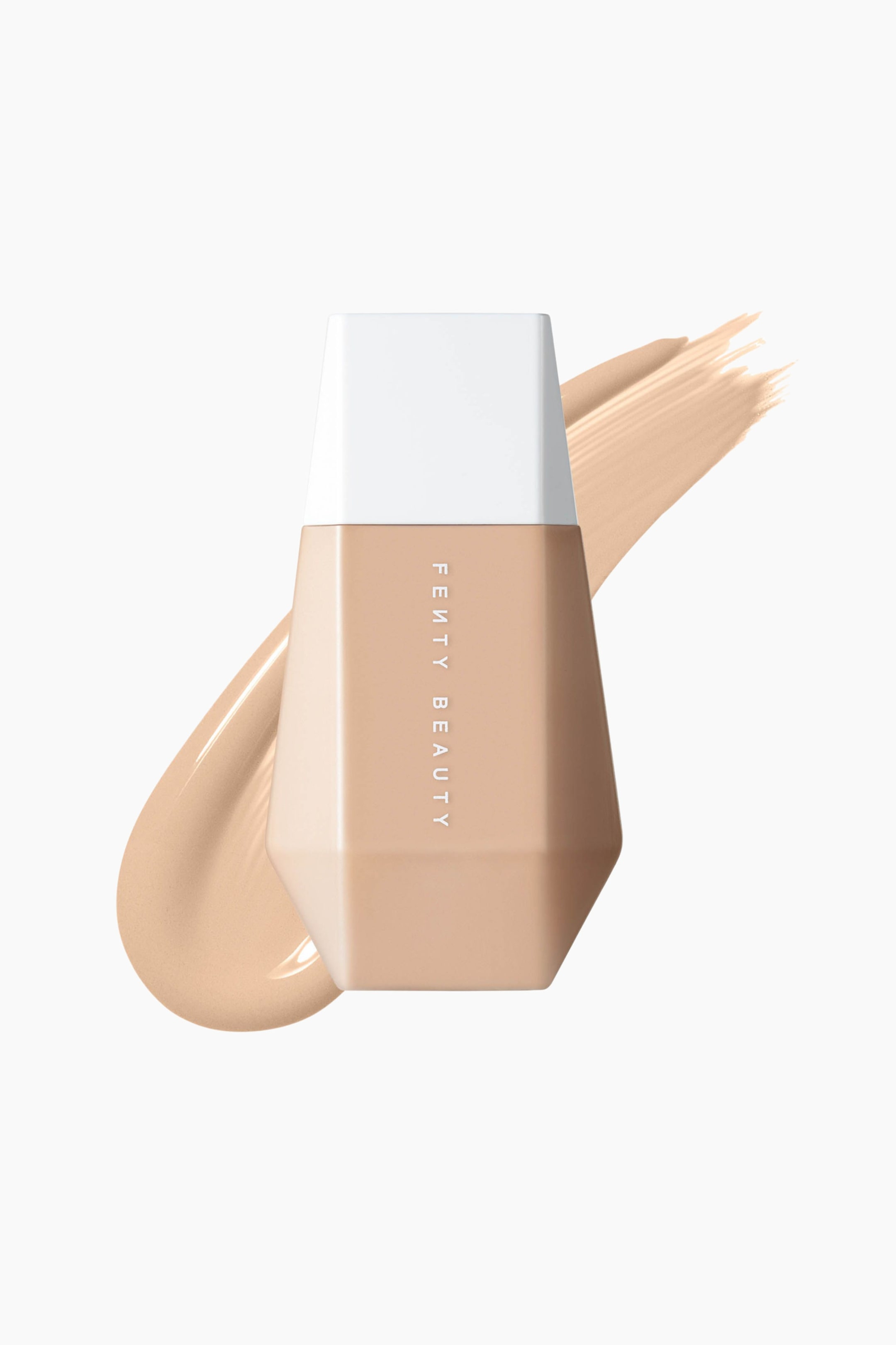 Visa större bild: En frontvänd, geometriskt formad klämflaska med Fenty Beauty Eaze Drop skin tint står upprätt, med vitt lock och en vertikal varumärkeslogotyp. Ett tjockt, diagonalt svep av den matchande ljusbeige flytande formulan löper bakom flaskan och visar dess släta konsistens.
