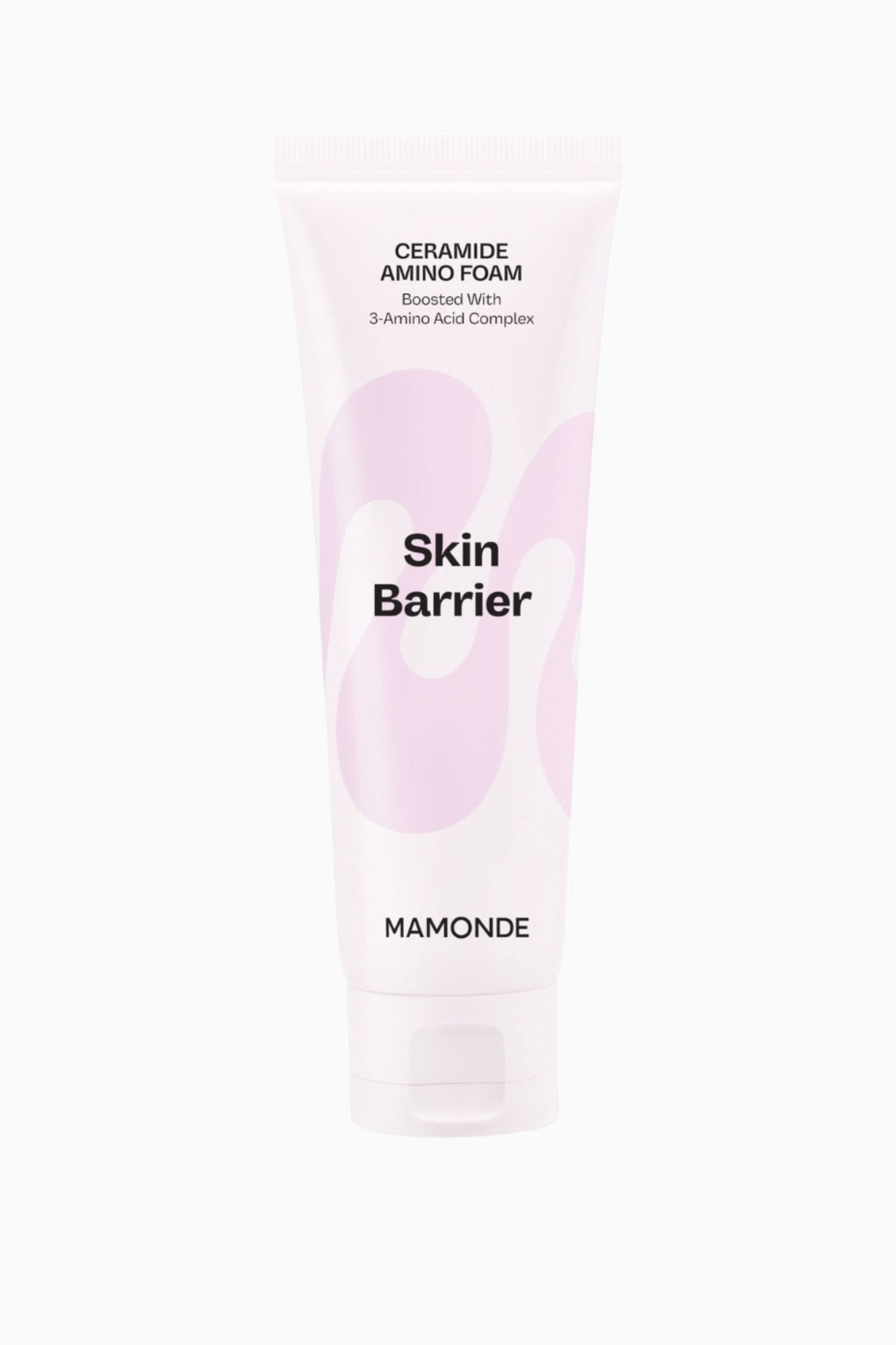 Visa större bild: En vit och ljusrosa tub av Mamonde Ceramide Amino Foam står upprätt och vänd framåt. Tuben visar texten "CERAMIDE AMINO FOAM", "Boosted With 3-Amino Acid Complex", "Skin Barrier" och "MAMONDE" i svart text. Ljusrosa, abstrakta vågmönster pryder förpackningen, och den har ett vitt flip-top-lock vid basen.