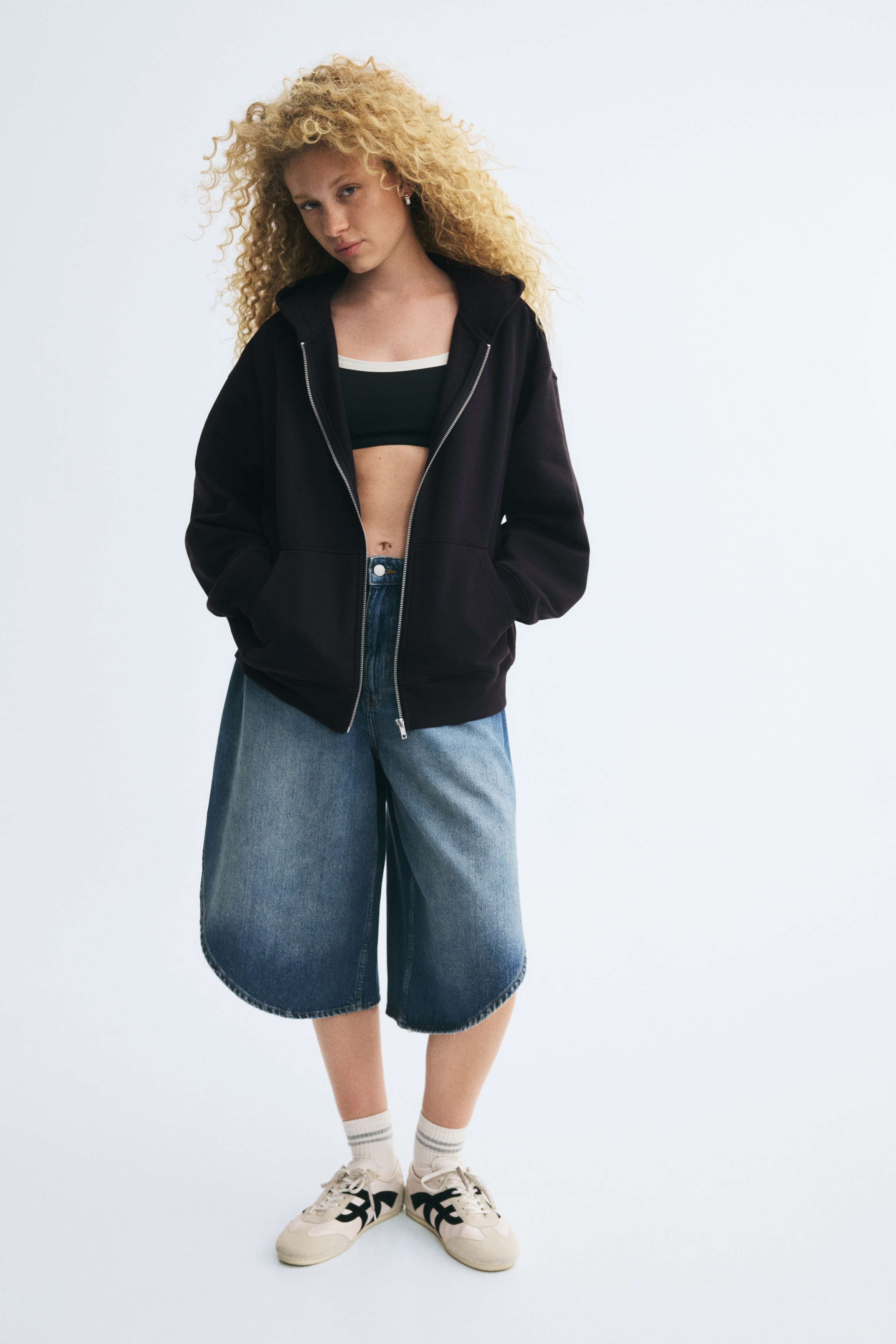 Má»t chiáº¿c hoodie mÃ u Äen cÃ³ khÃ³a kÃ©o Äang treo hÆ°á»ng ra phÃ­a trÆ°á»c, vá»i mÅ© trÃ¹m Äáº§u, khÃ³a kÃ©o mÃ u báº¡c á» giá»¯a vÃ  vai xuÃ´i. Sáº£n pháº©m cÃ³ tÃºi kangaroo chia ÄÃ´i á» máº·t trÆ°á»c, cÃ¹ng bo tay vÃ  bo gáº¥u Ã¡o dá»t rib.
