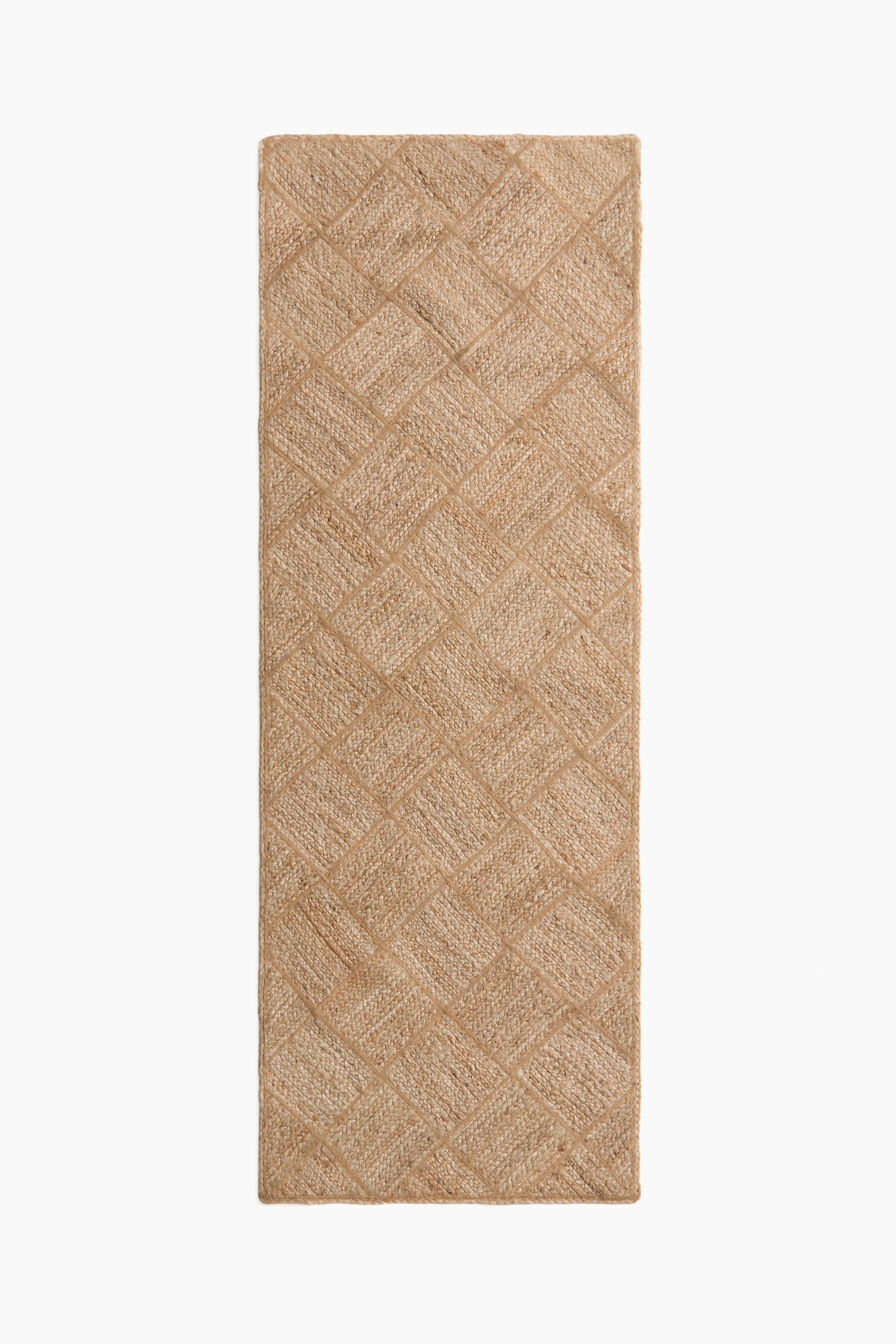 Grotere afbeelding bekijken: De rechthoekige jute loper heeft een natuurlijke lichtbruine kleur en een geometrisch patroon van verweven diagonale weefsels die ruitvormen vormen.