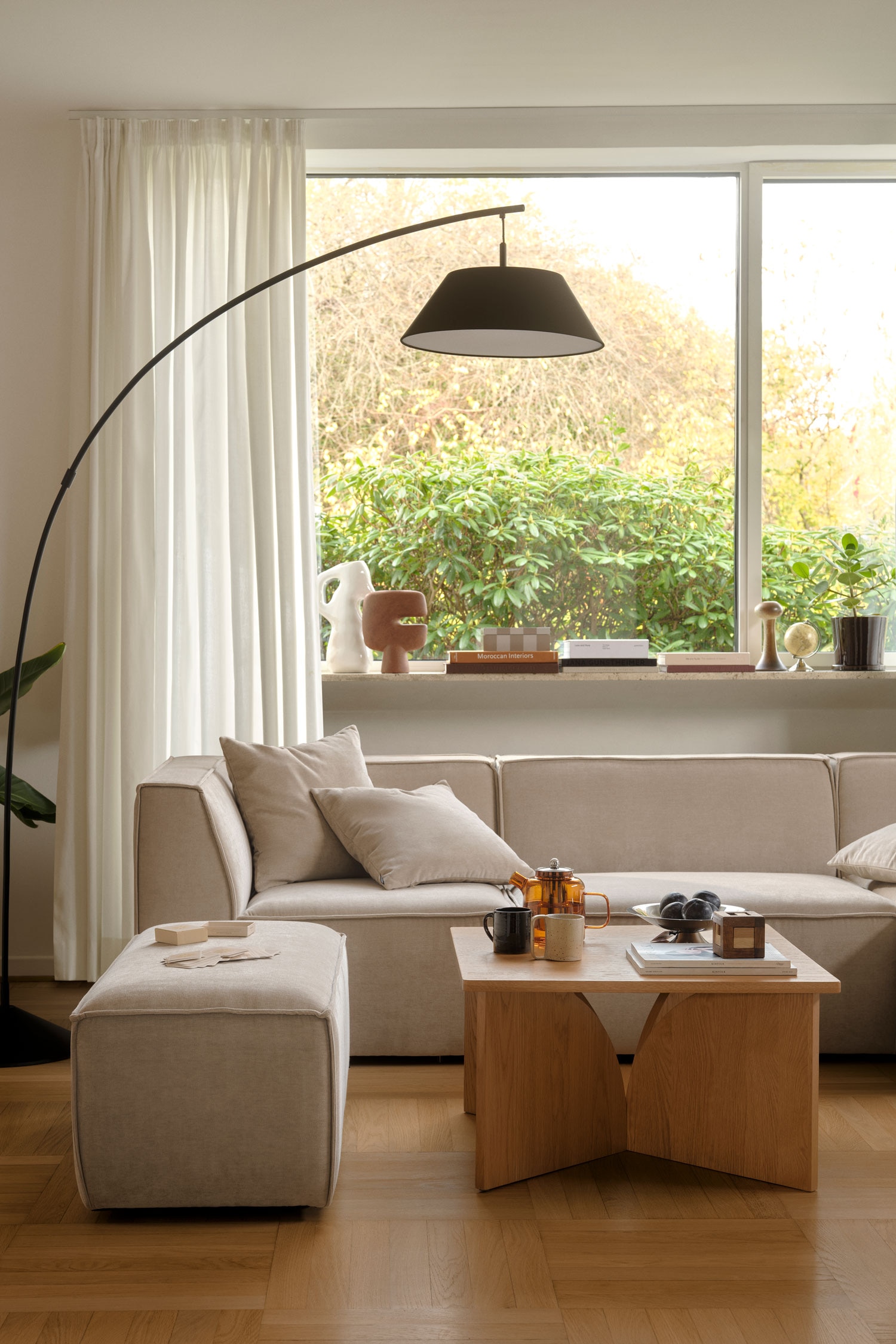 Une table console en bois aux tons clairs met en valeur un plateau plat et rectangulaire reposant sur deux panneaux de base sculpturaux et incurvÃ©s. Ces panneaux sâinclinent vers lâintÃ©rieur en direction du centre, crÃ©ant un espace nÃ©gatif symÃ©trique en forme dâarche sous la table.