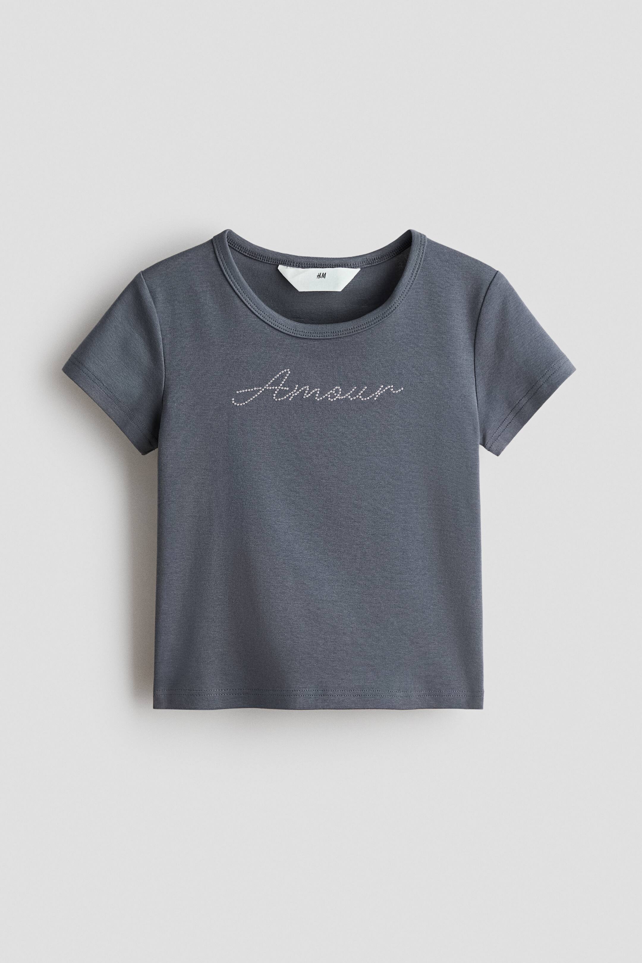 View larger image: A dark grey T-shirt is presented from the front, featuring a round neckline and short sleeves. The word "Amour" is sparkling in cursive text across the chest.