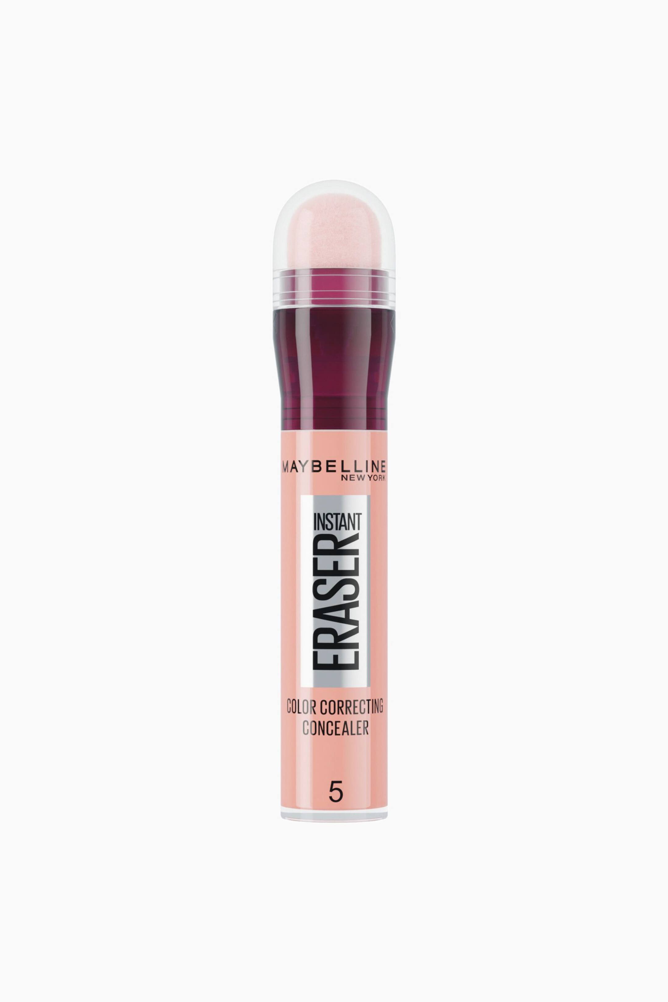 Se større billede: En Maybelline Instant Eraser Color Correcting Concealer står lodret og vender fremad, så dens ferskenfarvede cylindriske hylster med sort og sølvfarvet tekst er tydeligt synlig. Tubens top viser en mørk bordeauxfarvet halsring og en kuppelformet, lyserosa svampeapplikator under en gennemsigtig plastikhætte.