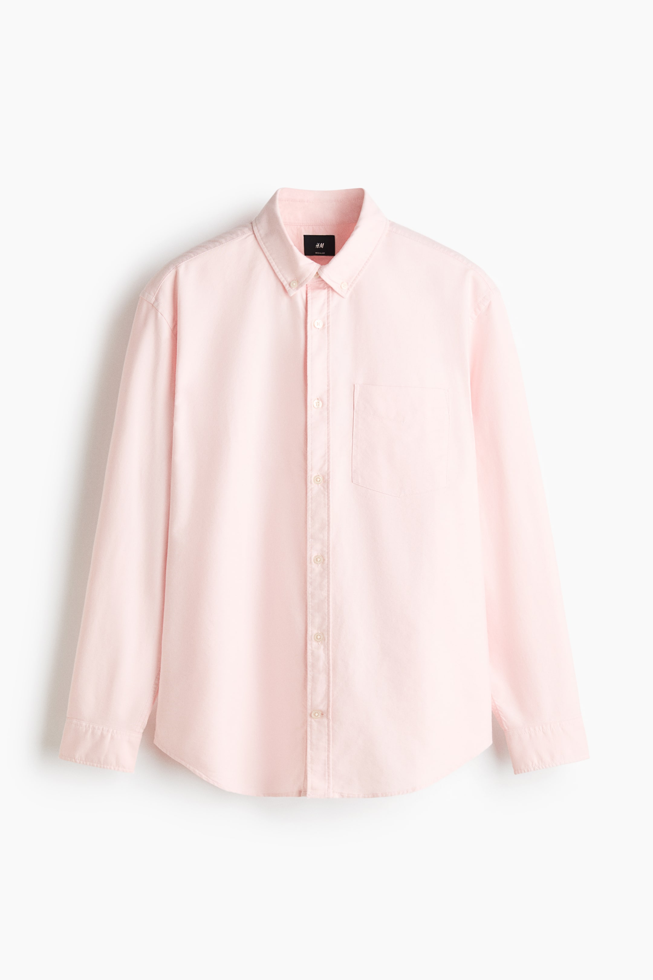View larger image: A light pink oxford cotton shirt is shown from the front, featuring a button-down collar, a classic button placket, and one open chest pocket. It is designed with long sleeves, button cuffs, a sleeve placket with a link button, and a gently rounded hem.