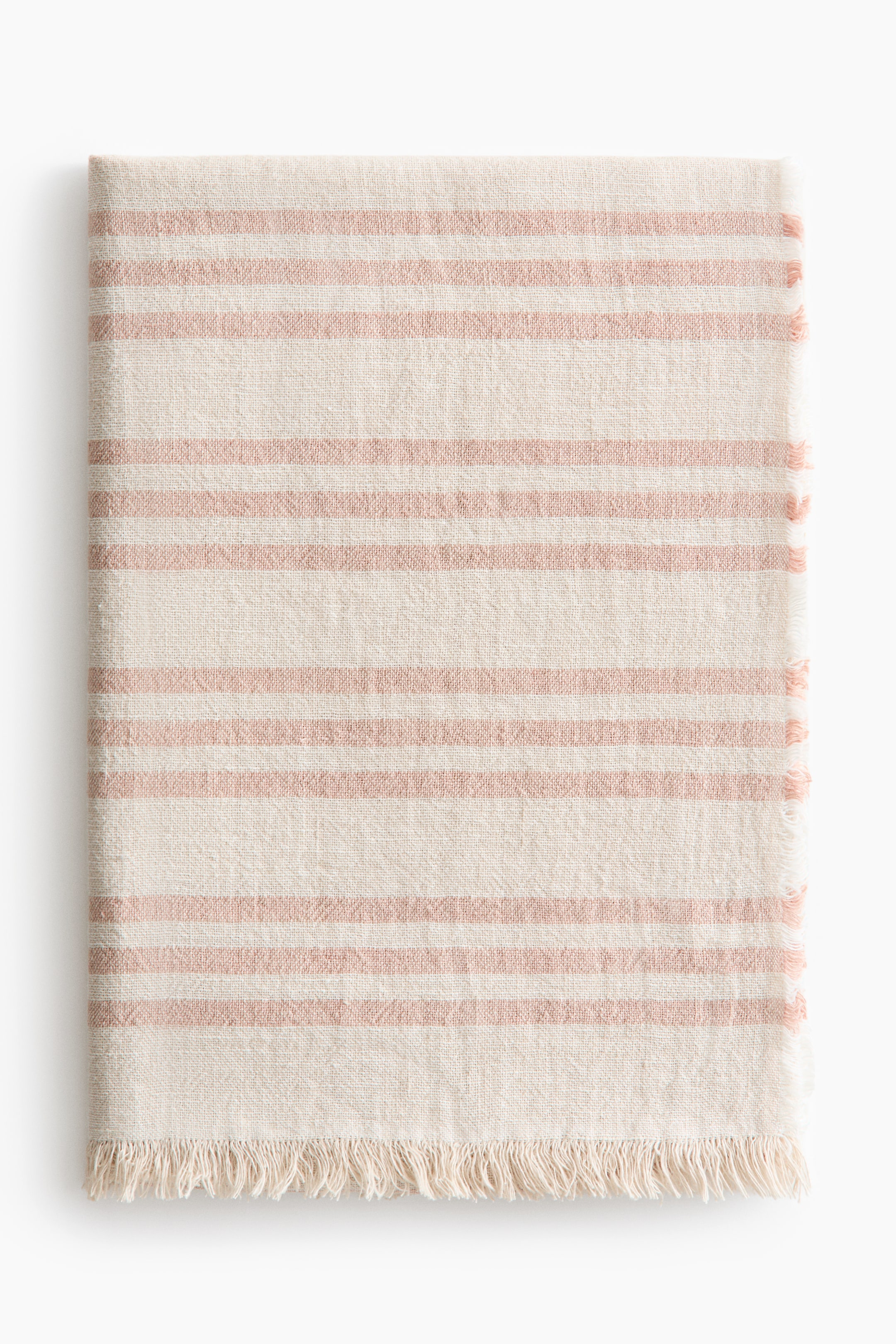View larger image: A folded striped textile with a visible plain weave displays horizontal light pink stripes on an off-white base, featuring fringed edges along the bottom and right sides.