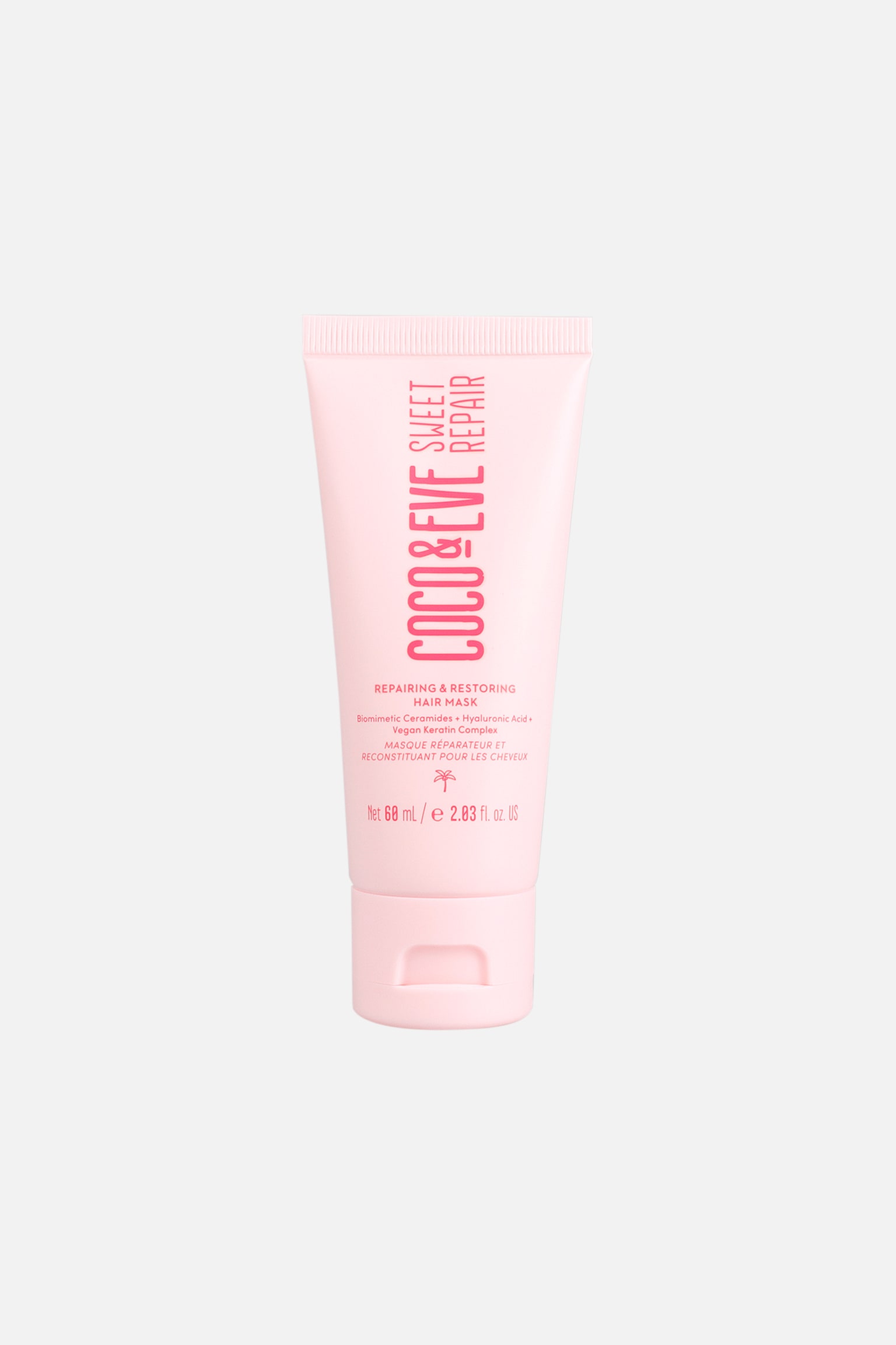 En tub med Coco & Eve Sweet Repair Hair Mask står upprätt i frontvy och visar en ljusrosa klämförpackning med matchande flip-top-kork. Tubens framsida visar tydlig vertikal rosa text med ”COCO & EVE SWEET REPAIR” ovanför mindre tryckta produktdetaljer och en palmikon.