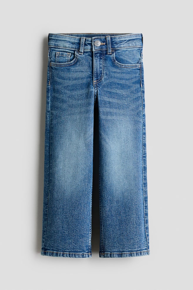 Blue denim jeans are displayed facing front, featuring a light wash with fading on the thighs. They are showcasing a button closure, belt loops, and front pockets, including a coin pocket, and are designed with straight legs. - 1