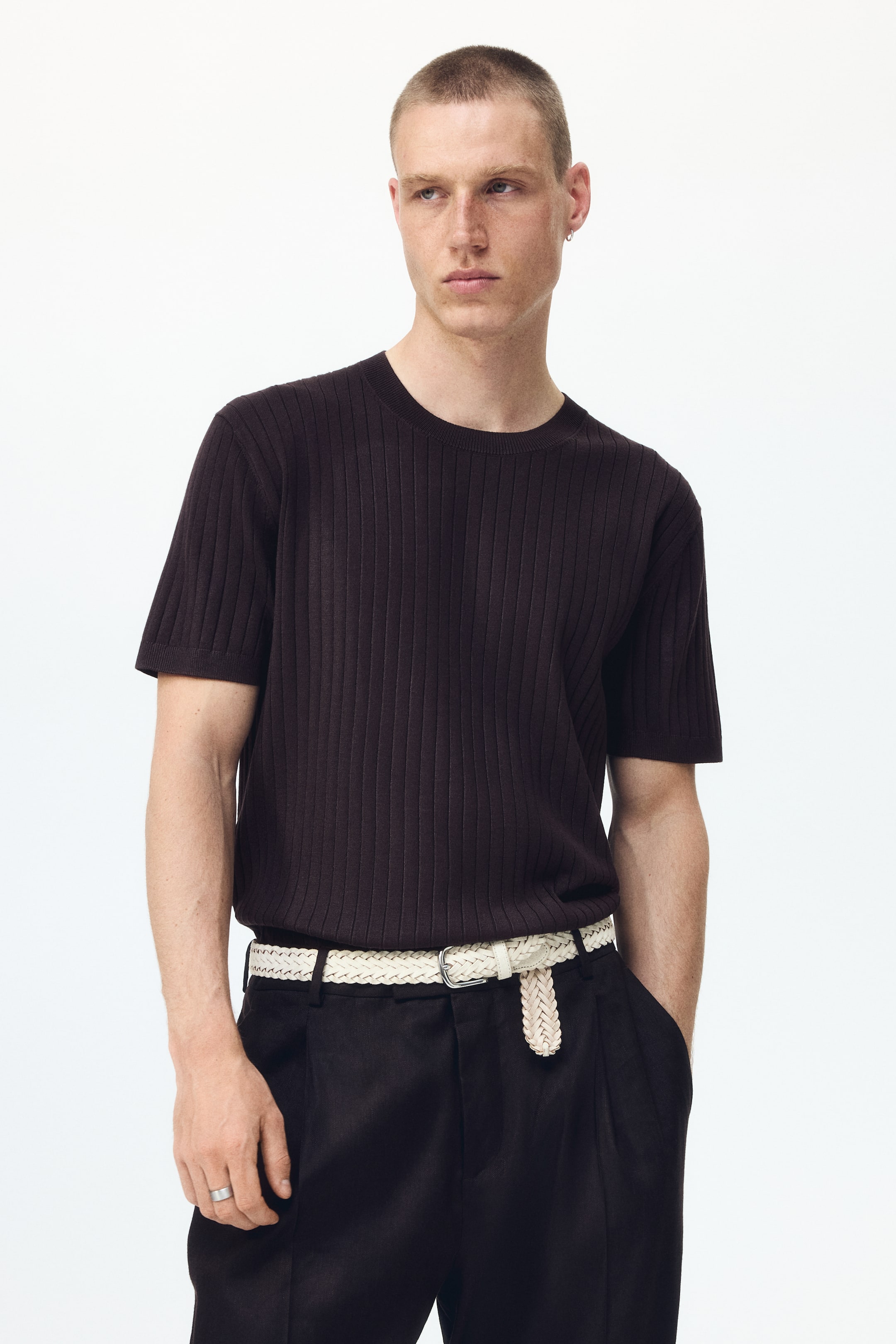 View larger image: A dark brown ribbed knit short-sleeve top featuring a crew neck and short sleeves. It showcases a fitted silhouette with prominent vertical ribbing, presented from a front-facing angle.