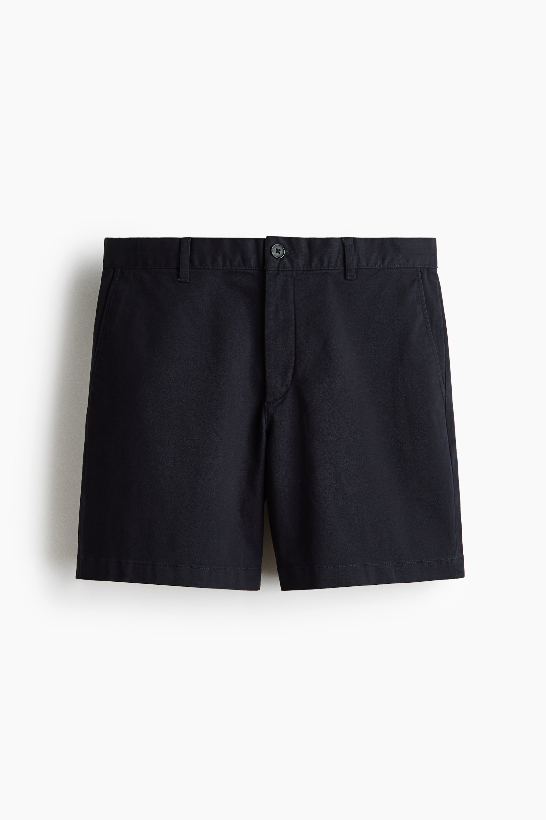 View larger image: Dark-colored chino shorts present a regular fit from the front. They feature a button and fly closure at the waist, along with diagonal side pockets.
