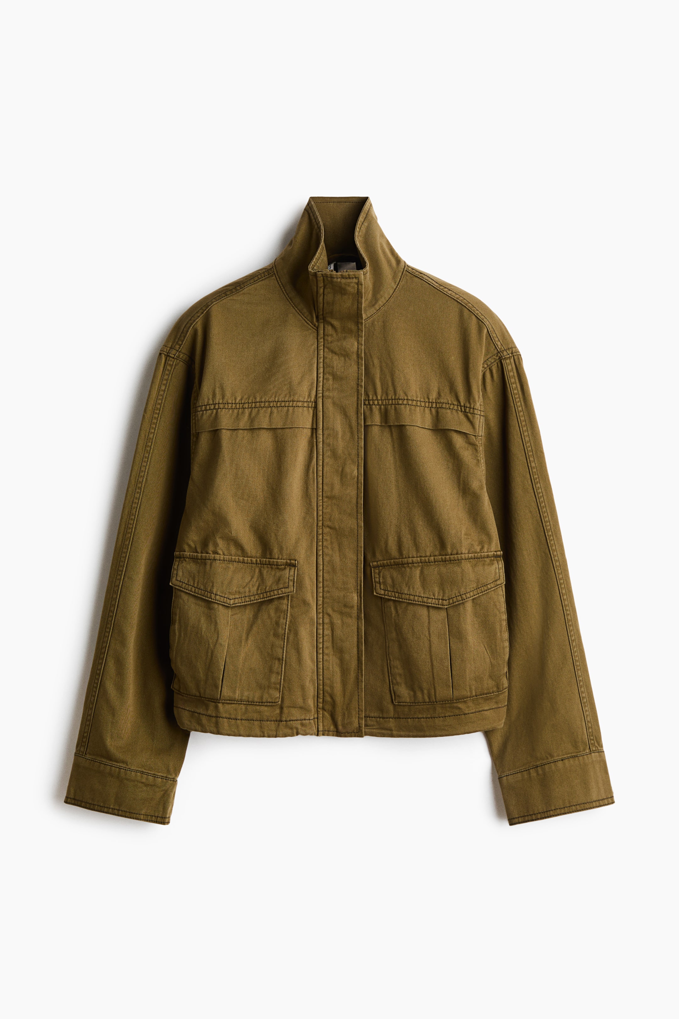 Agrandir l'image: Une veste utilitaire vert olive est dotée d’un col droit et d’une patte de boutonnage dissimulée sur le devant. Elle présente deux poches poitrine à rabat rectangulaires et deux poches inférieures à rabat plissées. Des surpiqûres visibles soulignent les découpes de la veste, et sa longueur légèrement courte lui confère une allure moderne.