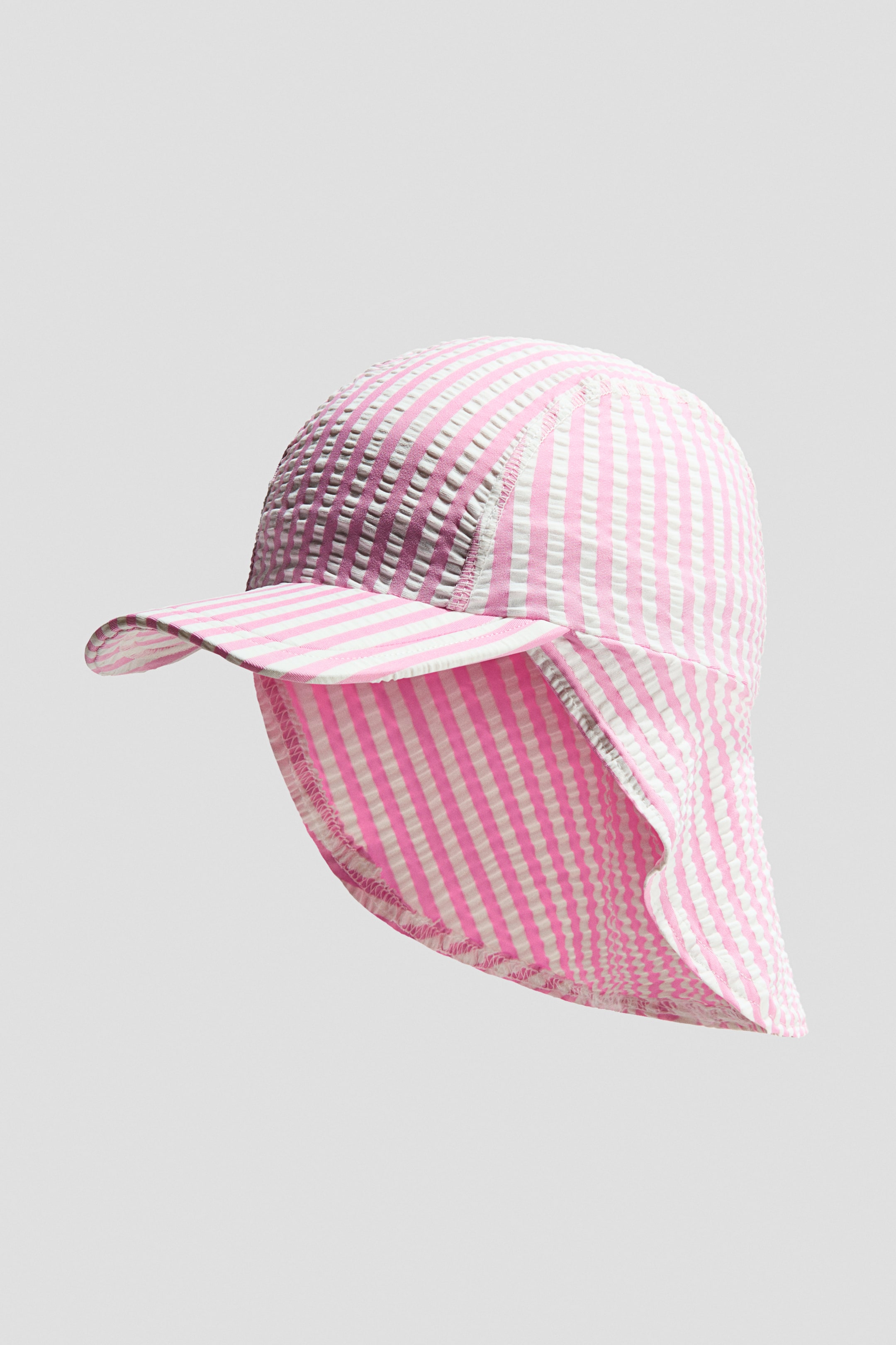 View larger image: This sun hat showcases a pink and white striped seersucker pattern. It features a curved front brim and a neck flap that extends from the back.