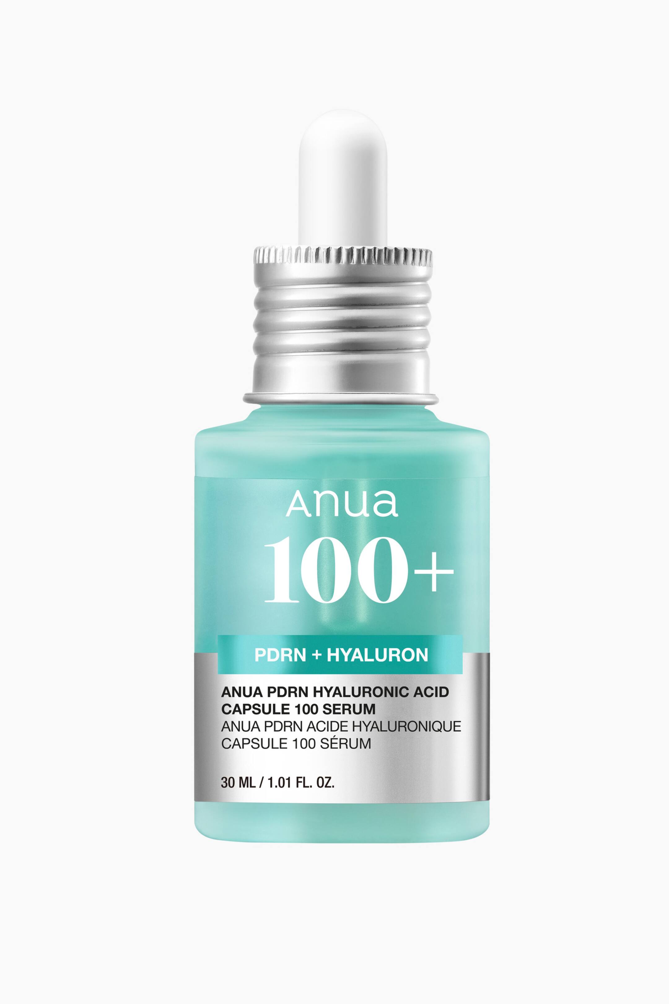 Visa större bild: En front-facing vy av serumflaskan Anua PDRN Hyaluronic Acid Capsule 100, med en ljus turkos genomskinlig glasflaska toppad med en räfflad silverfärgad halsring och en vit pipettkula. Flaskan visar varumärkesnamnet "Anua" och "100+" i vitt, tillsammans med ett silverband längst ned som innehåller produktinformationen.