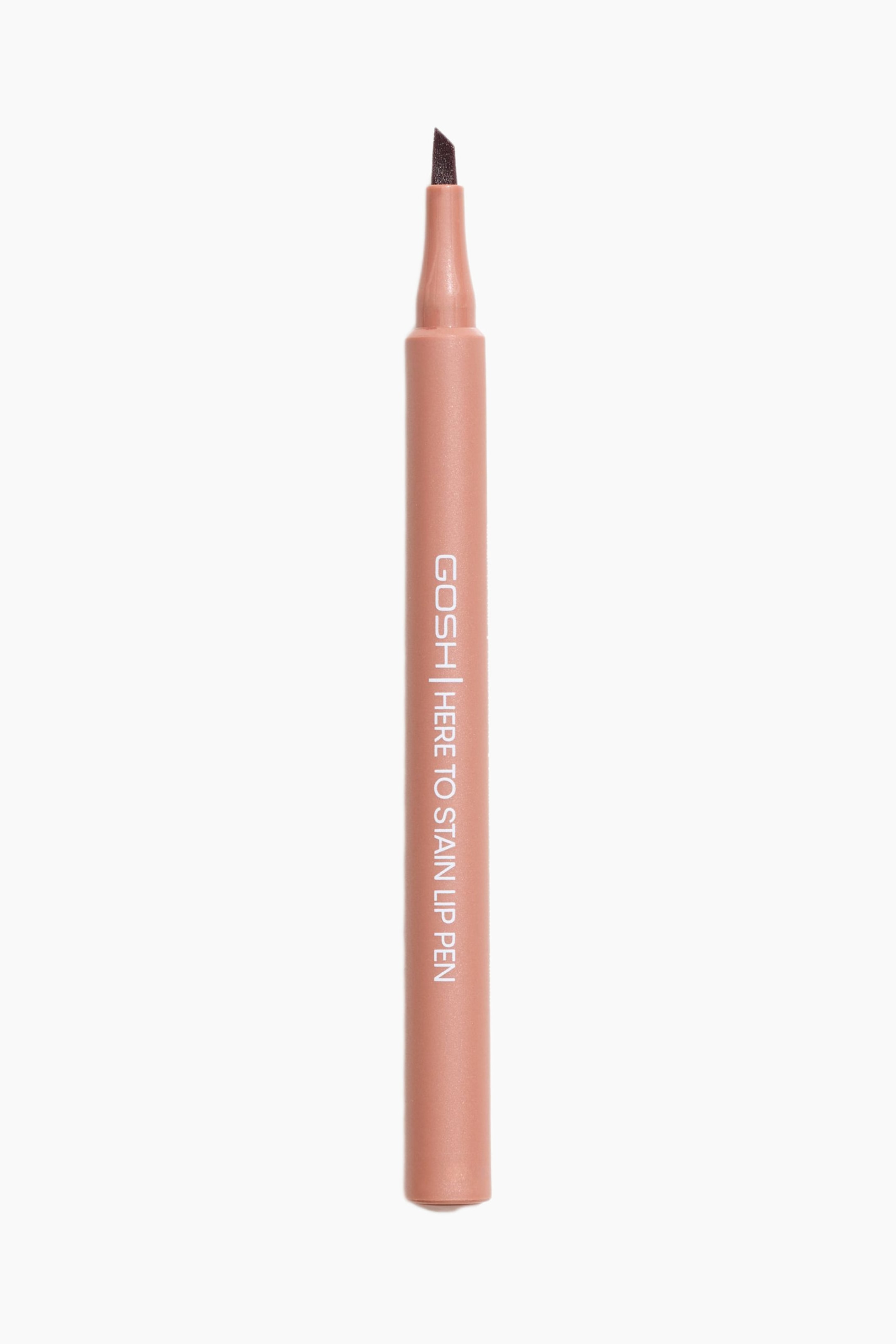 Visa större bild: En Gosh Here To Stain Lip Pen står upprätt och visar sin persikorosa cylindriska kropp och mörkbruna vinklade filtspets.
