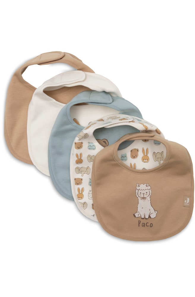 Un lot de cinq bavoirs pour bébé est disposé en chevauchement diagonal, mettant en valeur une palette de couleurs beige, blanc cassé et bleu poudré. La sélection comprend trois bavoirs de couleur unie, un bavoir orné dâun imprimé intégral dâanimaux de style cartoon, et, au premier plan, un bavoir beige présentant une illustration centrale dâalpaga avec le nom « Paco » inscrit en dessous. - 1