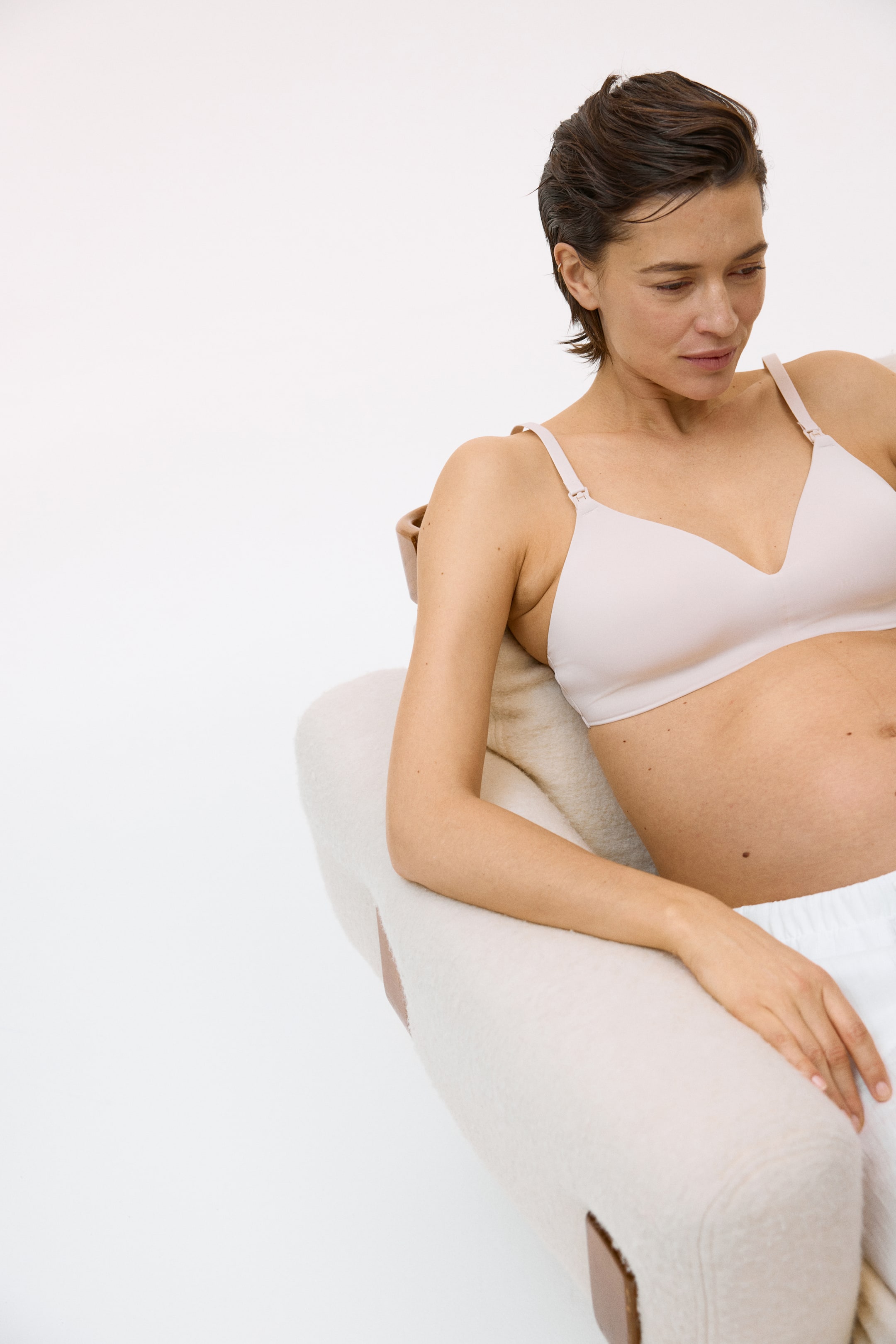 Se større billede: Den bløde, lyserøde amme-bh med polstrede skåle og ammeklips til åbning samt justerbare skulderstropper bæres af modellen.