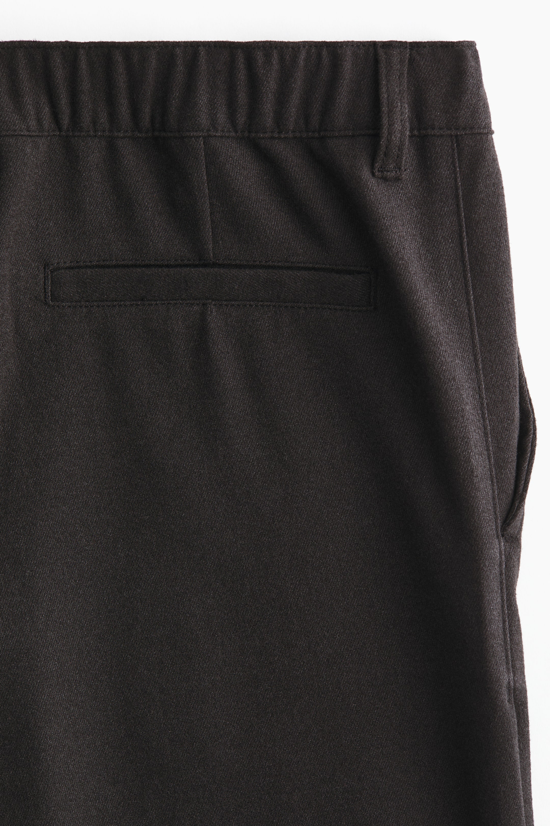 이미지 확대 보기: 짙은 갈색의 짜임이 있는 바지는 신축성 있는 허리밴드와 오른쪽에 벨트 고리가 있으며, 뒷면에 가로형 웰트 포켓이 있습니다. 오른쪽 측면에는 측면 솔기 주머니도 보입니다.