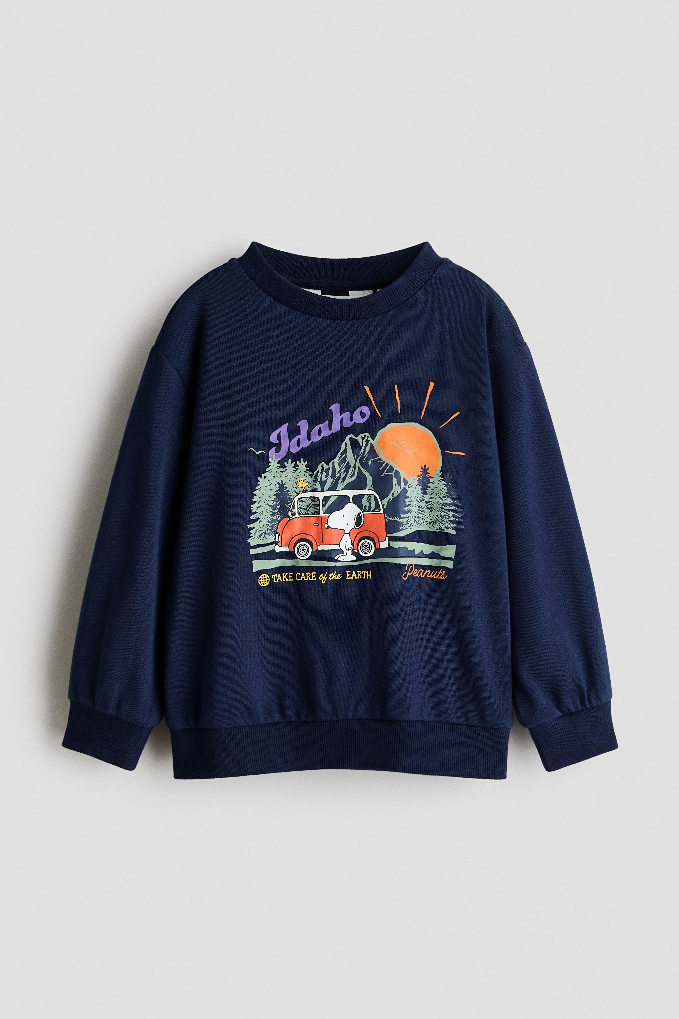 ã¢ãã«ãçç¨ãã¦ããã®ã¯ãSnoopyããã³ãããã¦ãIdahoãã®æå­ãããªã³ãããPeanutsã®ã°ã©ãã£ãã¯ãç¹å¾´ã®ãã¼ã¯ãã«ã¼ã®ã¹ã¦ã§ããã·ã£ãã§ããç½ãè¥ä»ãã·ã£ãã®ä¸ã«éã­ããã®ã»ã¼ã¿ã¼ã¯ãä¸¸ã¿ã®ãããªãããã¯ã©ã¤ã³ããã­ããã·ã§ã«ãã¼ãå¹åºã®ãªãã«ãã¹ãç¹å¾´ã§ãã