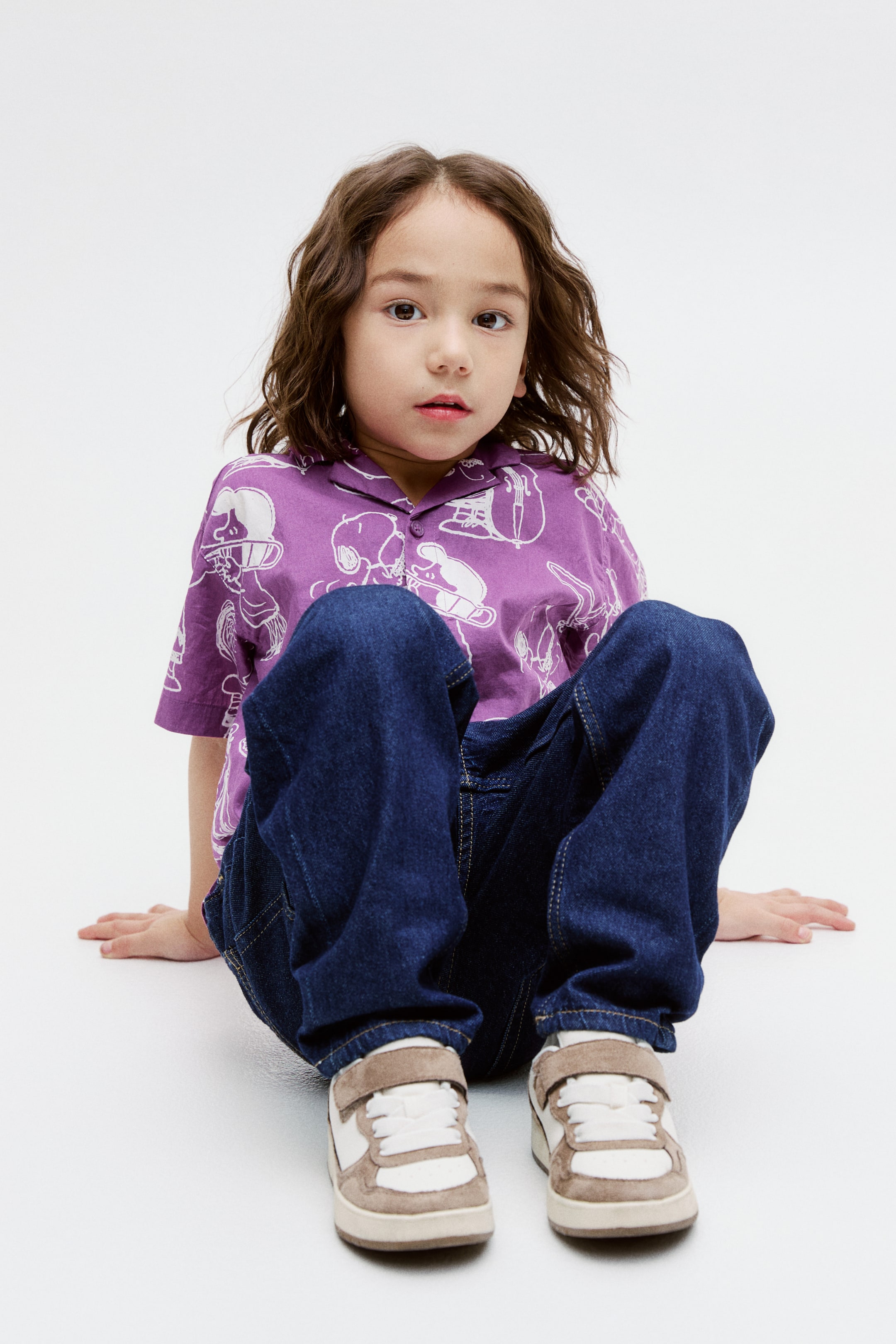 View larger image: The purple short-sleeved shirt showcases white character outlines, presented from a front angle. It is styled with a revere collar and white front buttons.