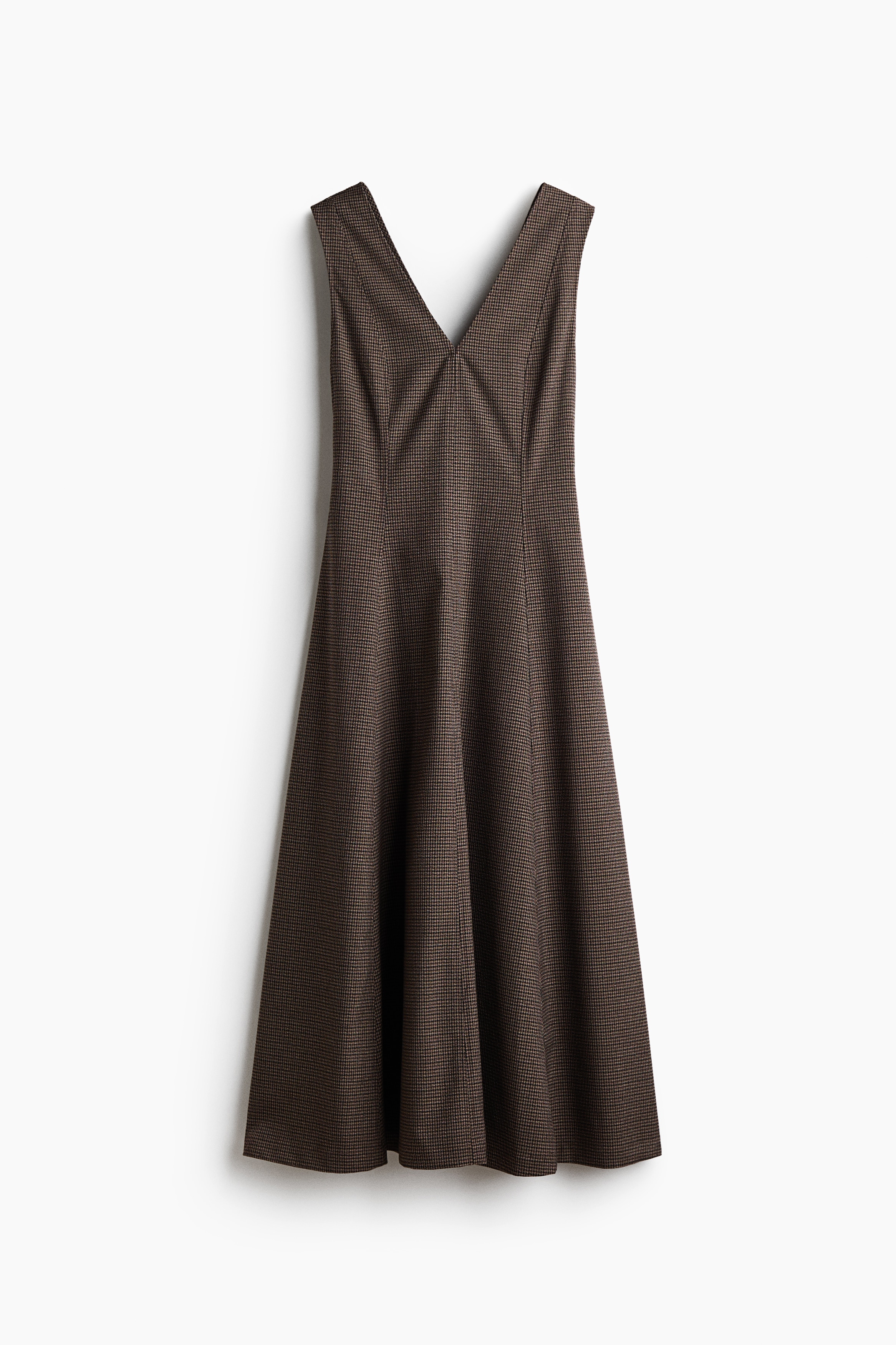 A calf-length, sleeveless dress in a brown patterned woven fabric is being worn by the model. The dress features a V-neckline, a fitted bodice with visible vertical seams, and a flared skirt.