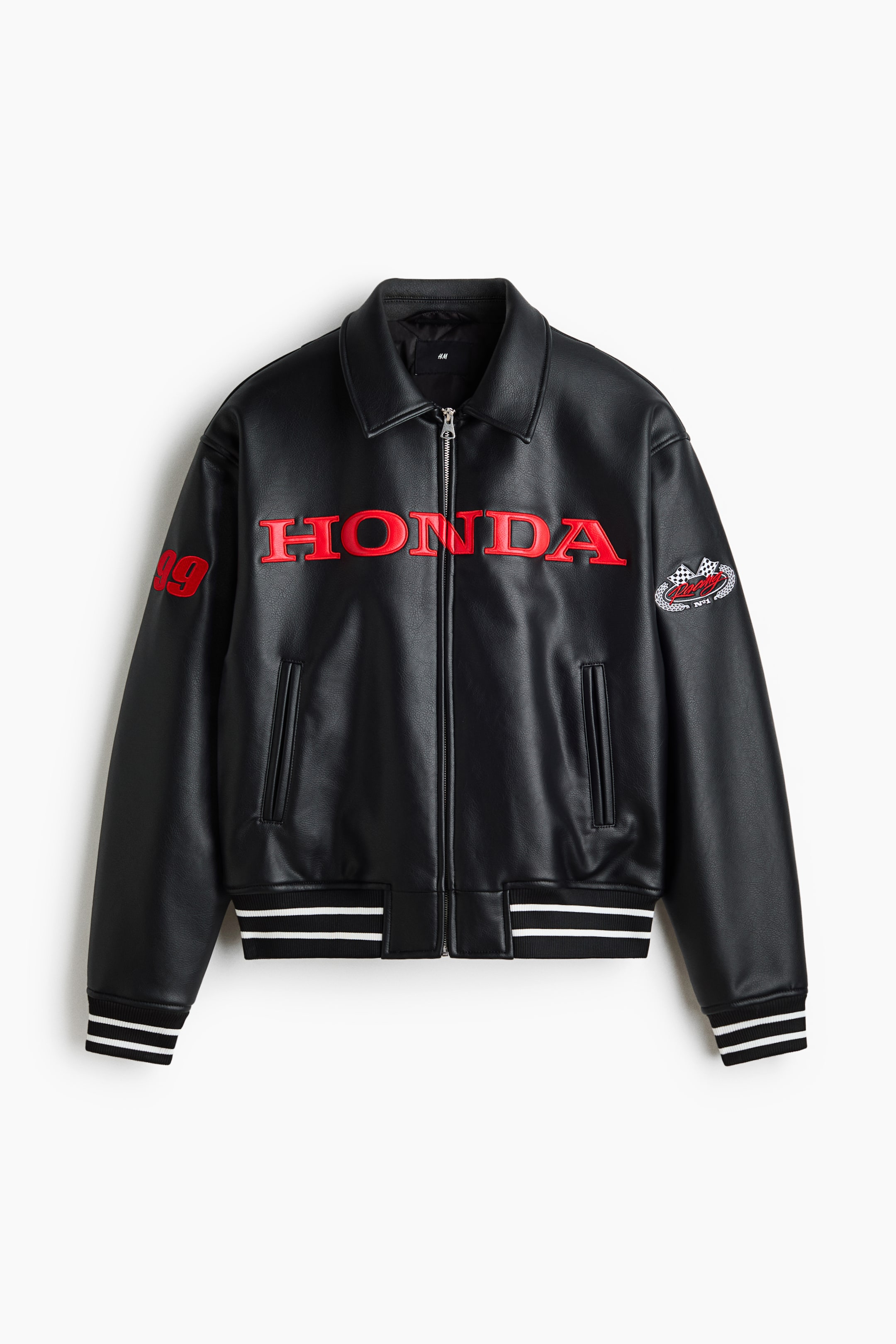 Ver imagen más grande: Una chaqueta bomber de aspecto cuero negro presenta un cierre frontal con cremallera y un cuello clásico. Exhibe "HONDA" en letras rojas en relieve a lo largo del pecho, un "89" rojo en el hombro izquierdo y un emblema circular de bandera a cuadros en la manga derecha, todo complementado por puños acanalados a rayas y un dobladillo acanalado a rayas.