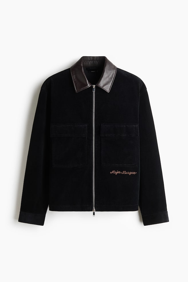 Frontansicht eines schwarzen Overshirts aus Cord mit kontrastierendem dunkelbraunem Kragen aus beschichtetem Stoff und einem silberfarbenen Zwei-Wege-ReiÃverschluss in der Mitte. Es verfÃ¼gt Ã¼ber zwei groÃe aufgesetzte Brusttaschen mit Patten, einen geraden Saum und den in hellbraun gestickten Schriftzug âMajor Leagueâ unterhalb der linken Tasche. - 1