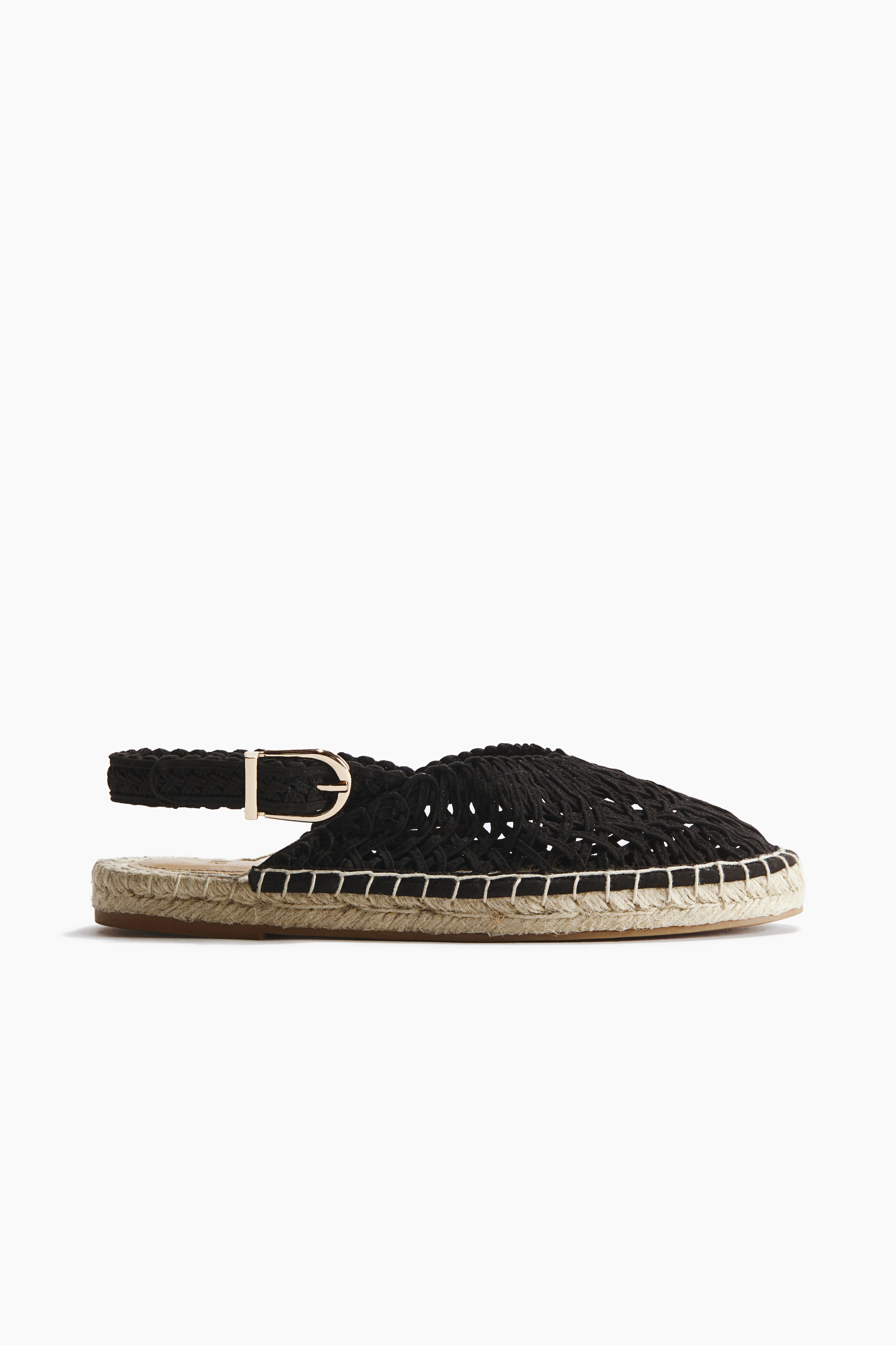 Grotere afbeelding bekijken: Een zwarte espadrille slingback sandaal met een geweven macramé bovenkant en een met jute omwikkelde zool, zichtbaar vanuit een zij-voorhoek. Witte stiksels benadrukken de verbinding tussen de bovenkant en de zool, terwijl een goudkleurige gesp de gevlochten slingback band vastmaakt.