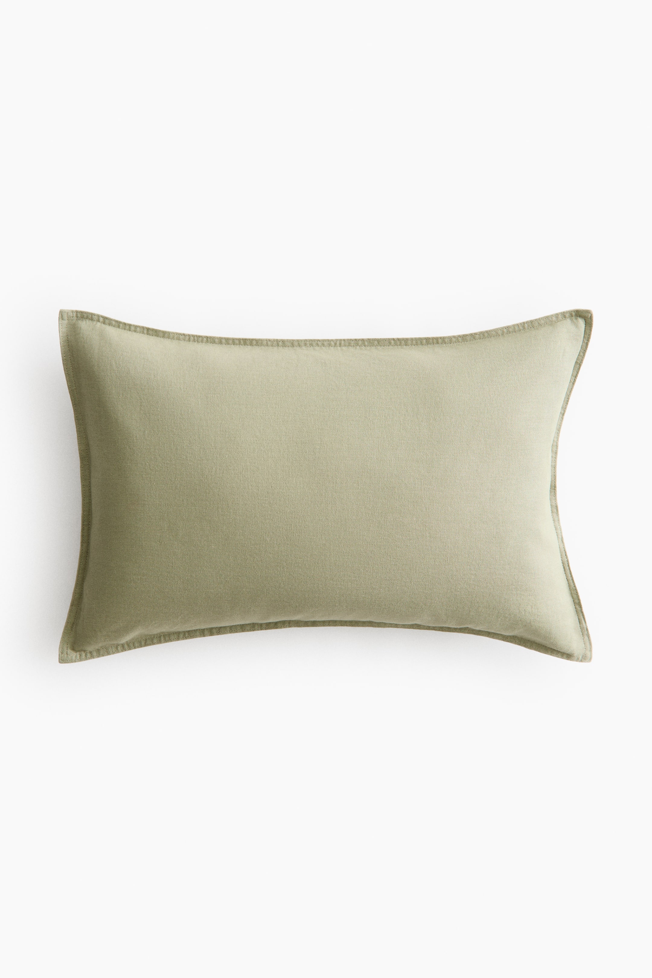 View larger image: The rectangular cushion cover showcases a light green linen and cotton weave. It features prominent stitching along all four sides, defining its edges.