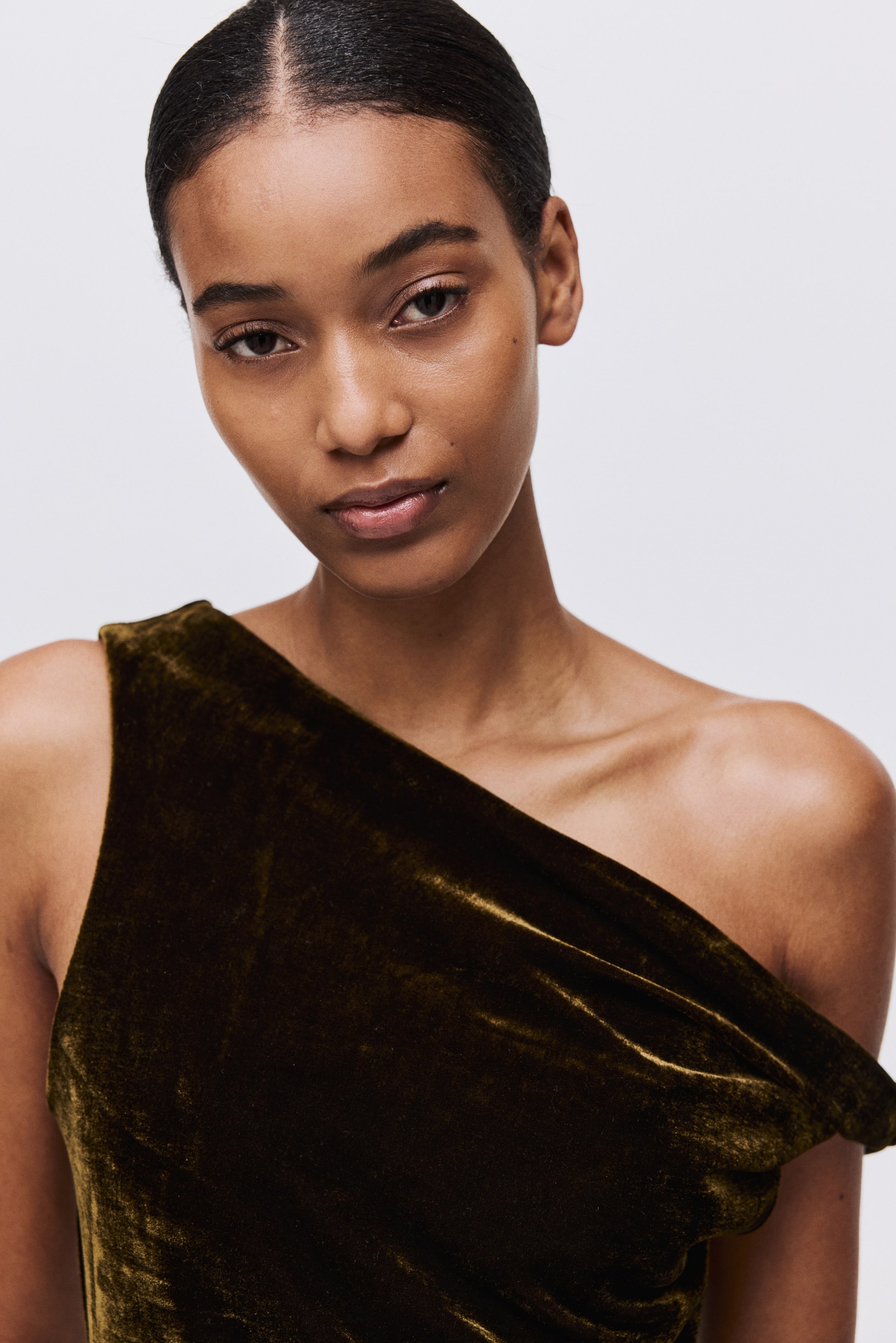 Näytä suurempi kuva: Tumman oliivinvihreä samettinen yksihiha vaate on suunniteltu drapeeratusti, muodostaen pehmeitä laskoksia ylävartalon ja olkapään yli.