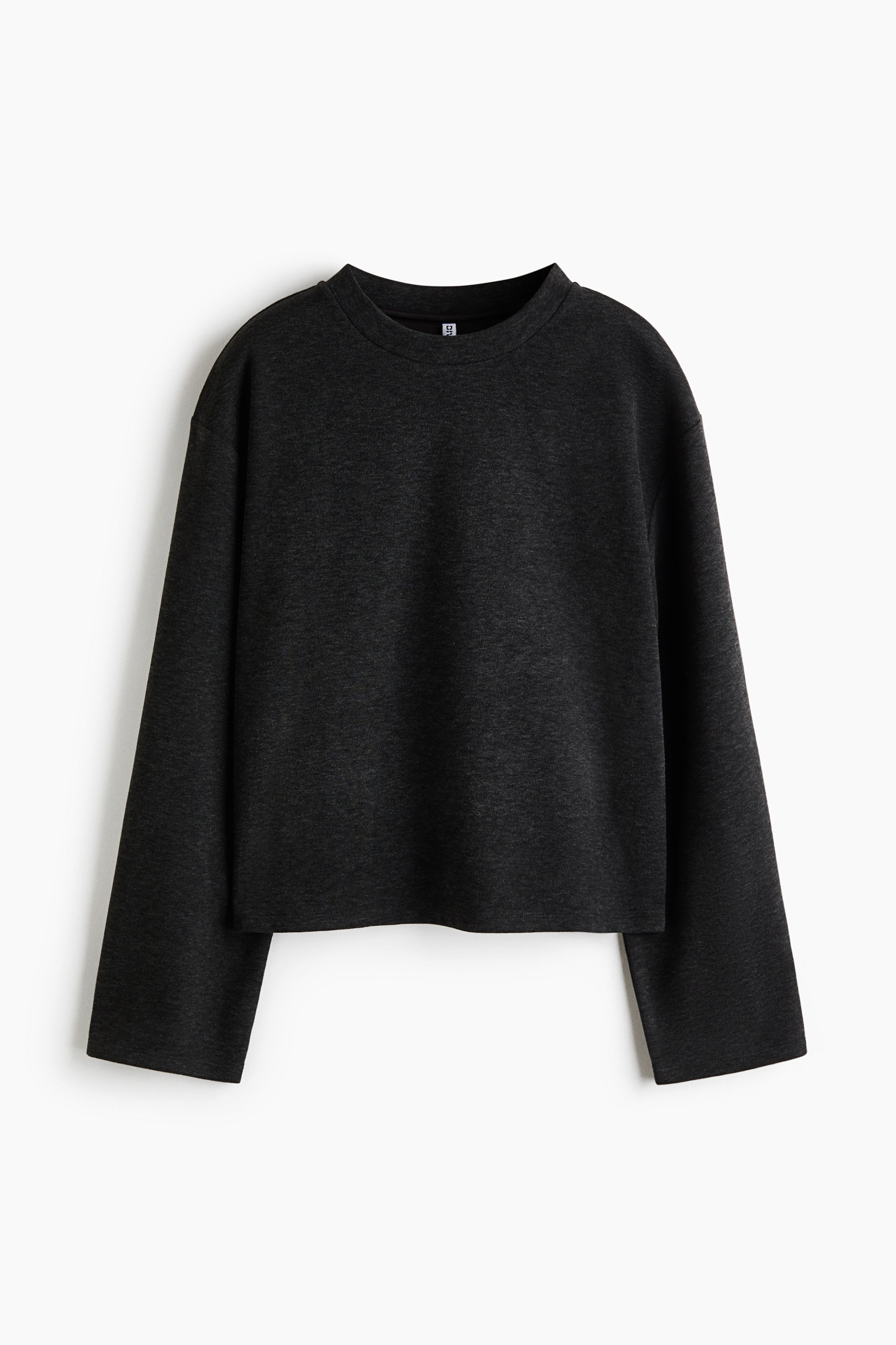 The model is wearing a dark grey sweater in brushed fleece fabric, featuring a round neckline, dropped shoulders, and long, wide sleeves. A black-and-white striped collar is visible layered beneath the sweaterâs neckline.