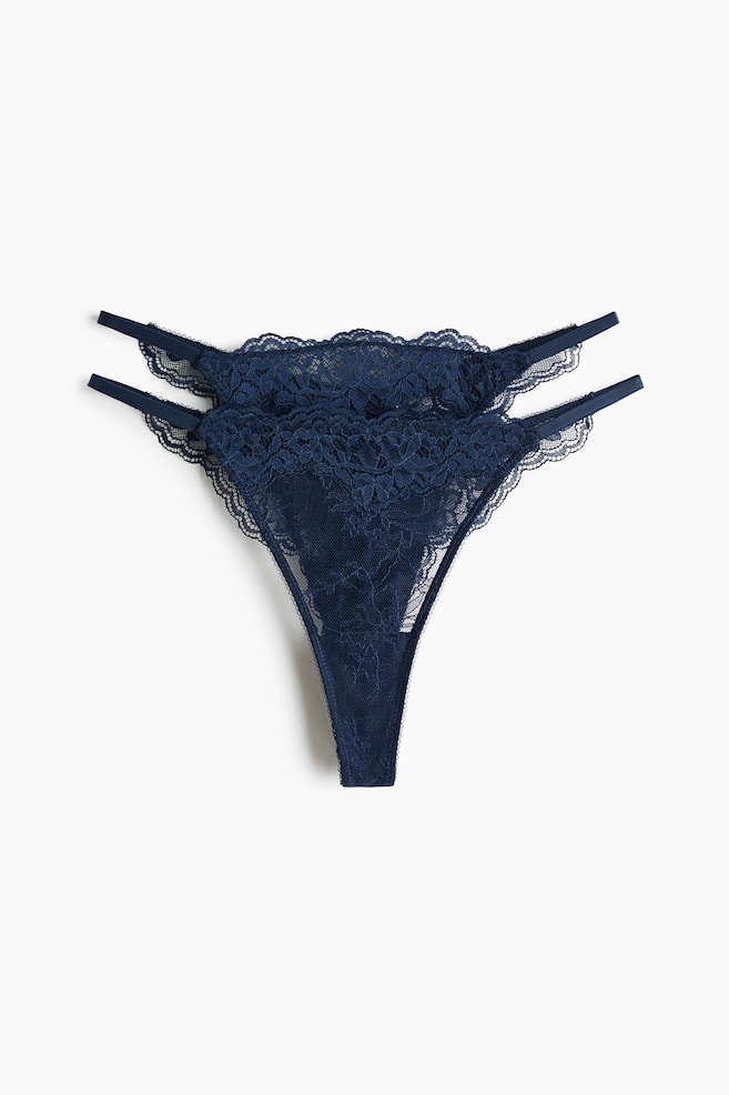 Two navy blue lace thong briefs are displayed, facing front. They feature a low waist with a scalloped lace edge, narrow double elastic straps on the sides, and a lined gusset. - 1
