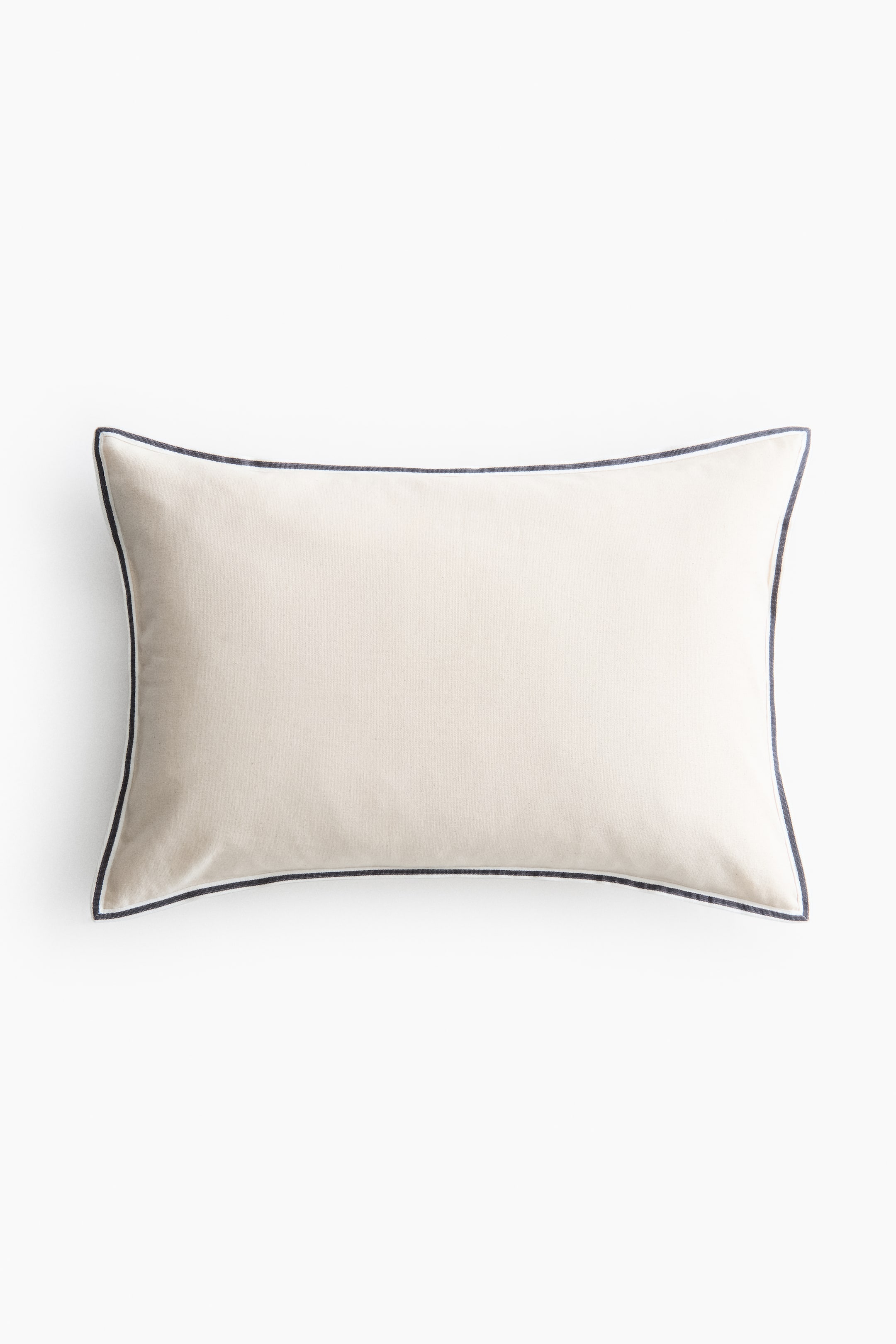 Prikaži veću sliku: Pravougaoni jastuk okrenut sprijeda prikazuje telo od tkanine boje slonovače. Detaljisan je tamnim pipingom koji formira ivicu duž sva četiri ruba, a koji je od glavne tkanine odvojen tankom belom linijom.