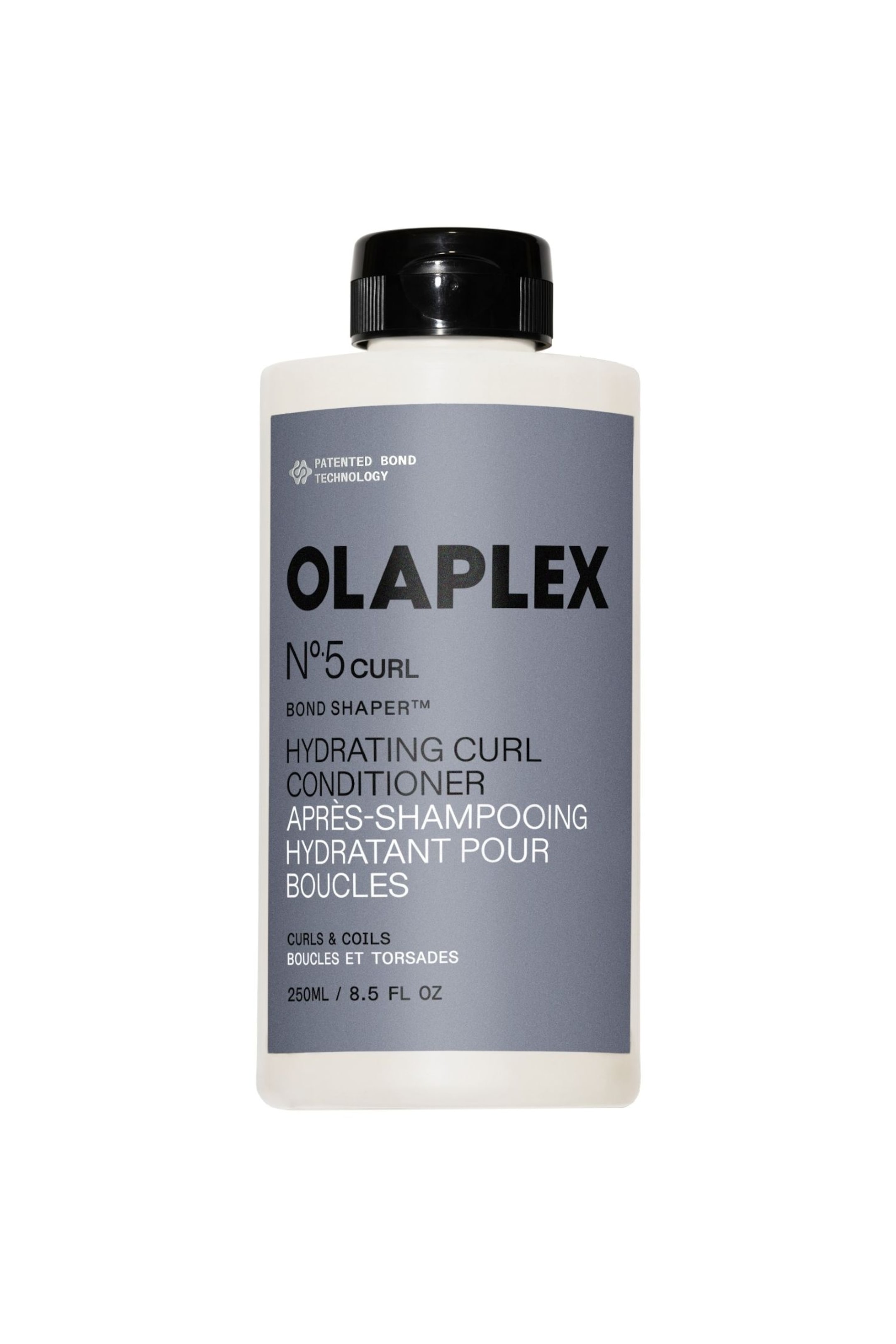 Vis større bilde: En rektangulær off-white flaske med Olaplex No. 5 Curl Hydrating Conditioner står oppreist, vendt forover. Den har en svart ribbet flip-top kork og en grå etikett som viser produktnavn, beskrivelse og volum i svart og hvit tekst.