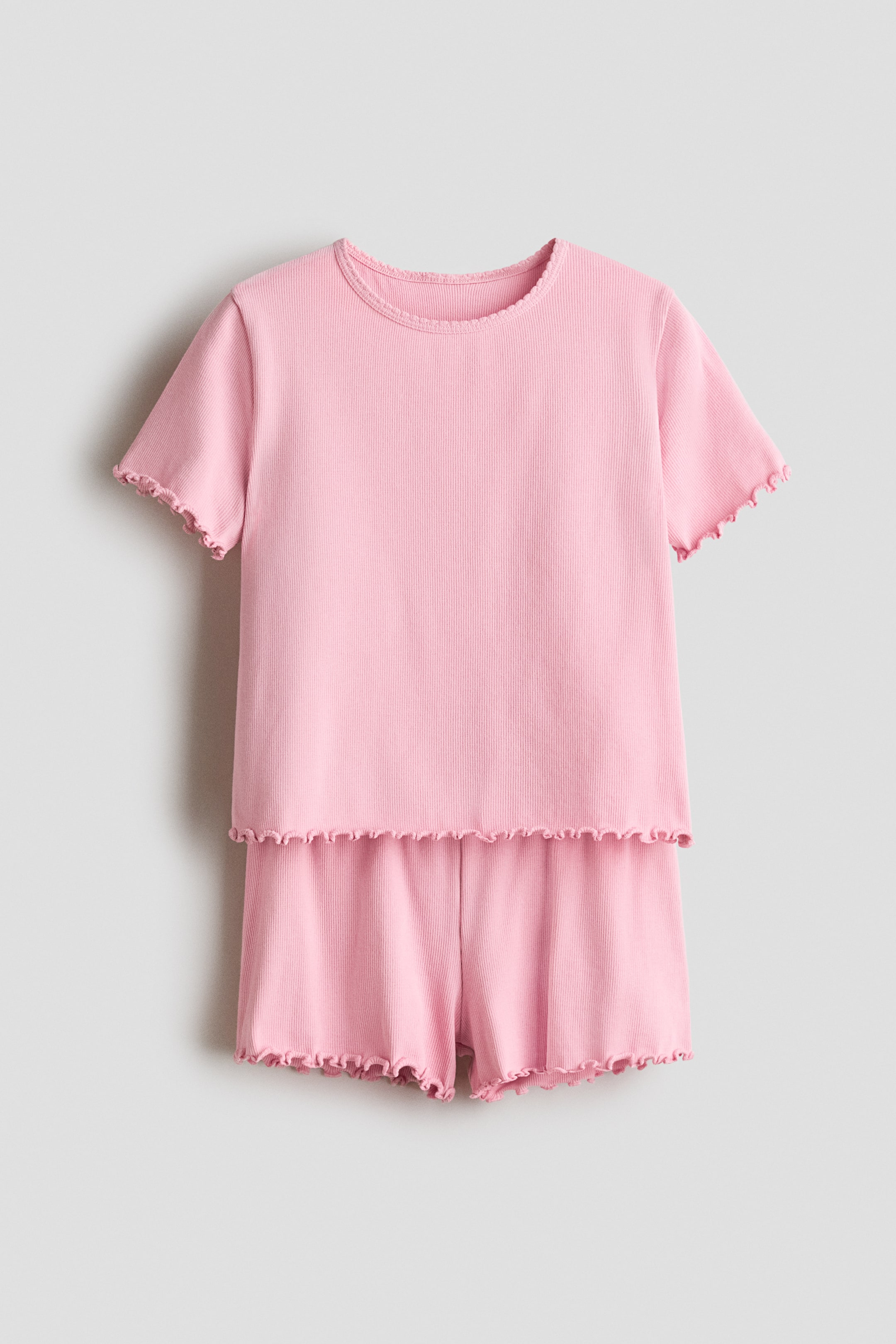 View larger image: Pyjamas featuring a top and shorts in ribbed cotton jersey, presented in a pink hue. The top boasts a round neckline with overlocked edges on the short sleeves and hem, while the shorts come with an elasticated waist and overlocked hems.