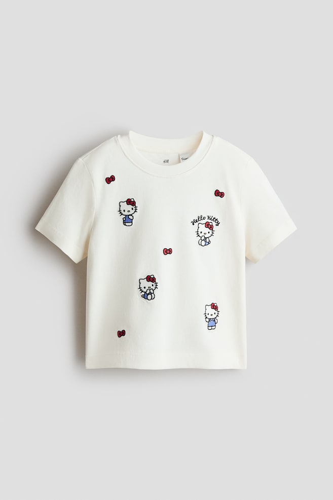 Baumwoll-T-Shirt mit Motivprint - Cremefarben/Hello Kitty/Rosa/Hello Kitty/Dunkelgrau meliert/Nirvana/Gelb/Miffy/Lila/K-Pop Demon Hunters/Rosa/Vaiana/Weiss/KPop Demon Hunters/Dunkelgrau/KPop Demon Hunters/Weiss/Zootopia/Weiss/KPop Demon Hunters - 1