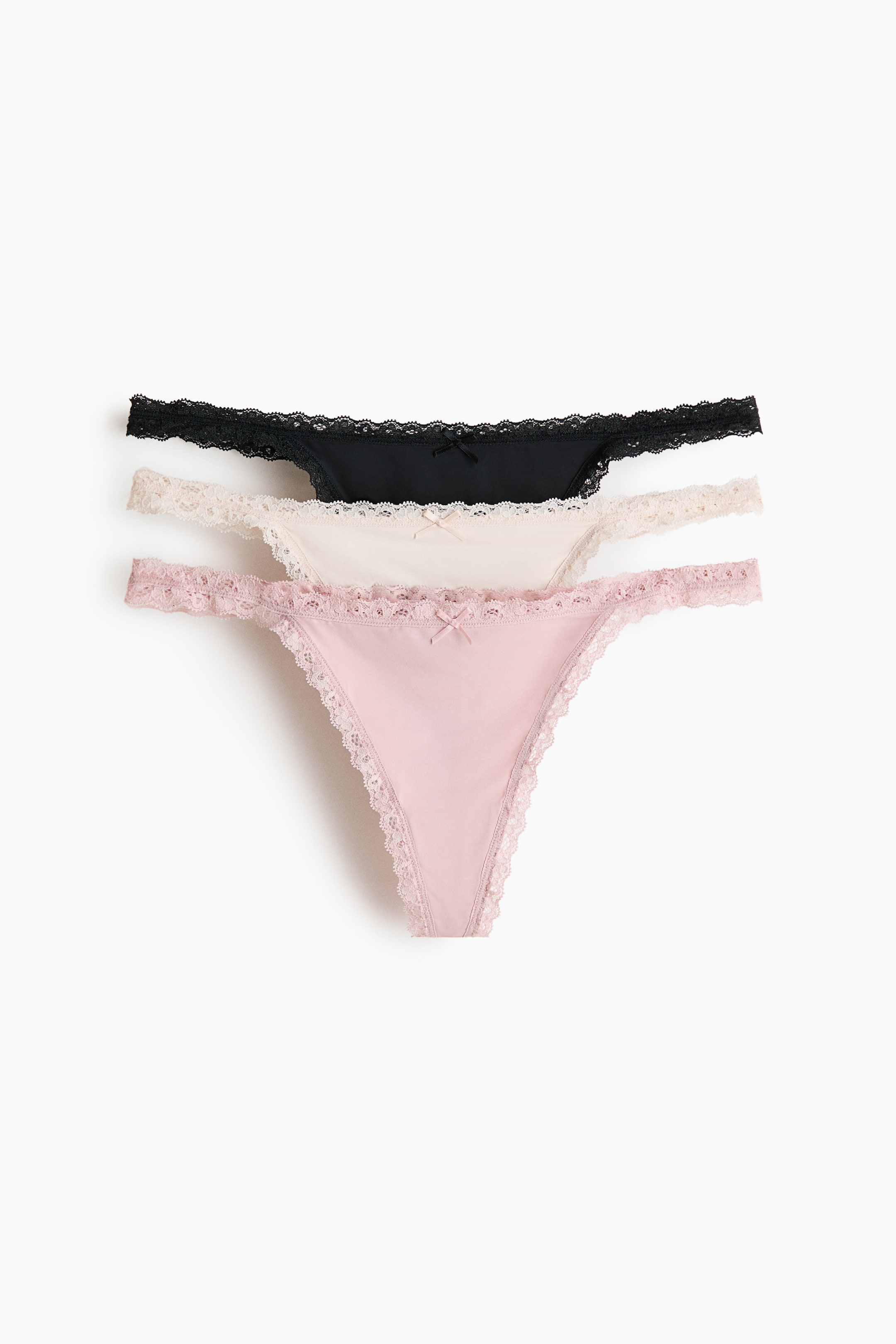 הצגת תמונה גדולה יותר: שלוש זוגות תחתוני טנגה ממיקרופייבר עם עיטורי תחרה מוצגים בחלק הקדמי, כשהתחתונים הוורודים, הבז'ים והשחורים נראים. הם מתאפיינים במותנים נמוכות, צדדים צרים, בטנות מרופדות וקשרים קטנים בחלק הקדמי.