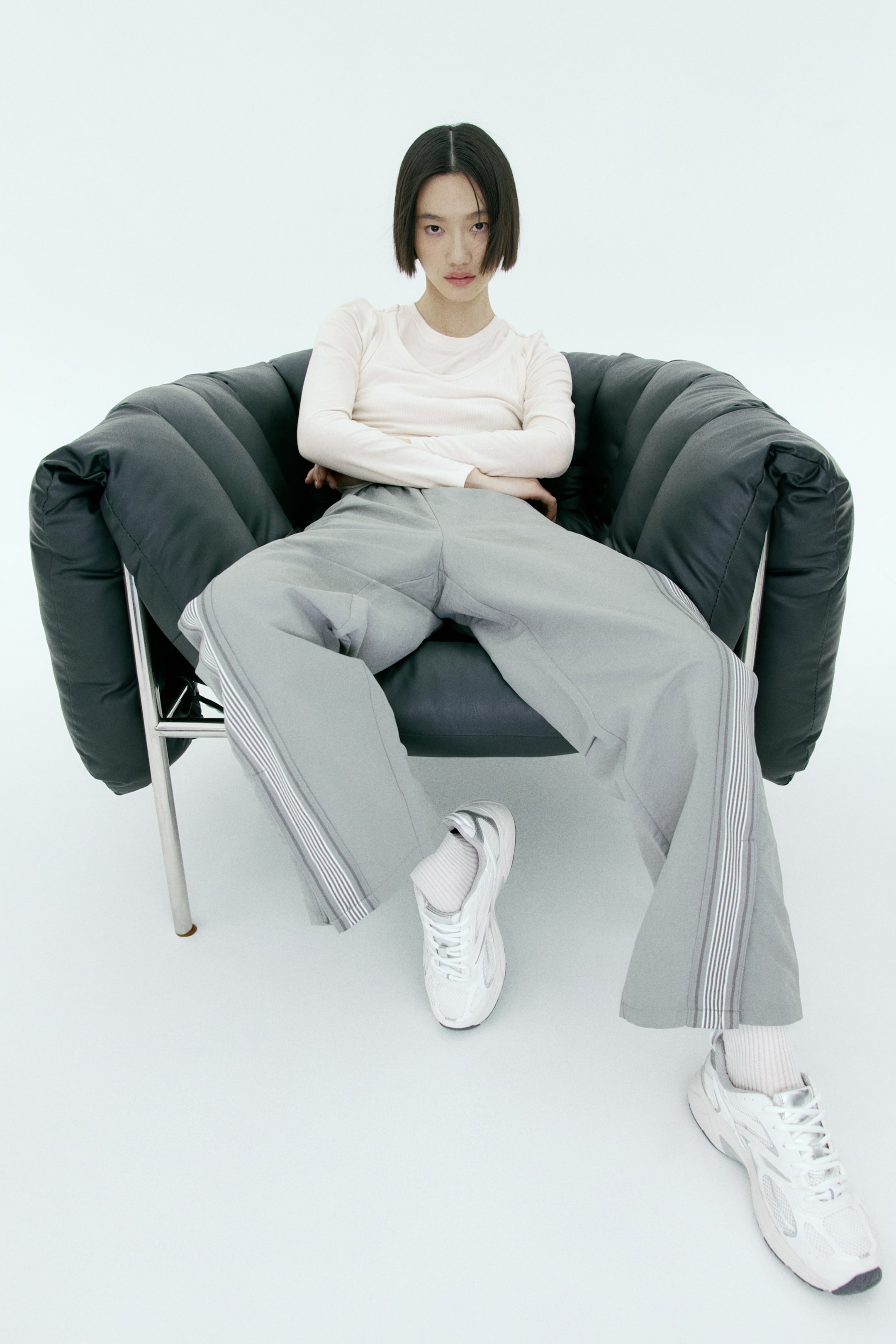 拡大画像を表示: ライトグレーのワイドパンツは、両脚の外側シームに沿った縦ストライプデザインが特徴です。ゆったりとしたリラックスフィットで、足首までの丈です。