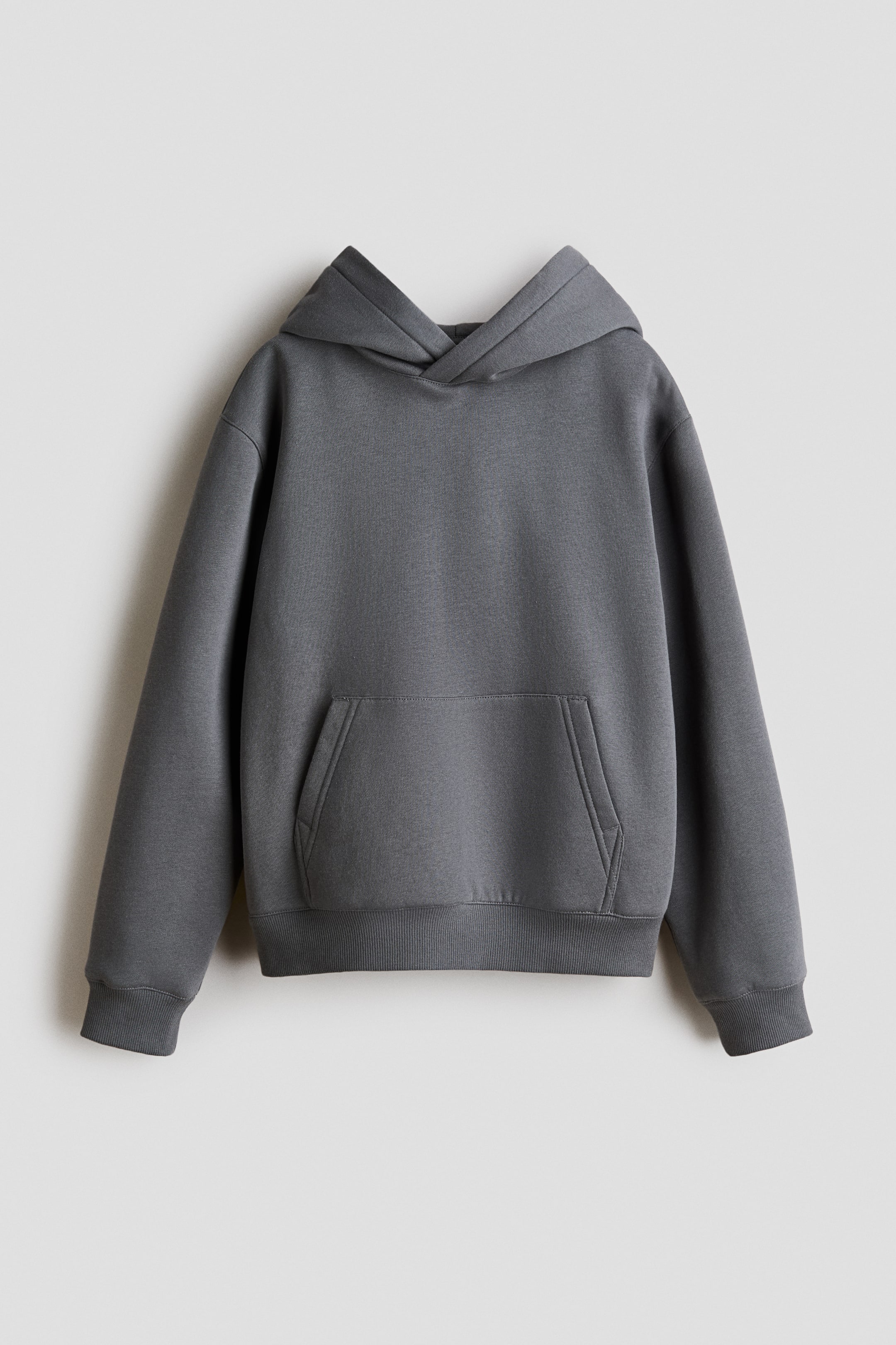 Ampliar la imagen: Se muestra una sudadera con capucha de color gris oscuro desde el frente. Presenta una capucha estructurada, mangas largas con puños acanalados y un dobladillo acanalado. Un gran bolsillo tipo canguro es visible en la parte inferior delantera.