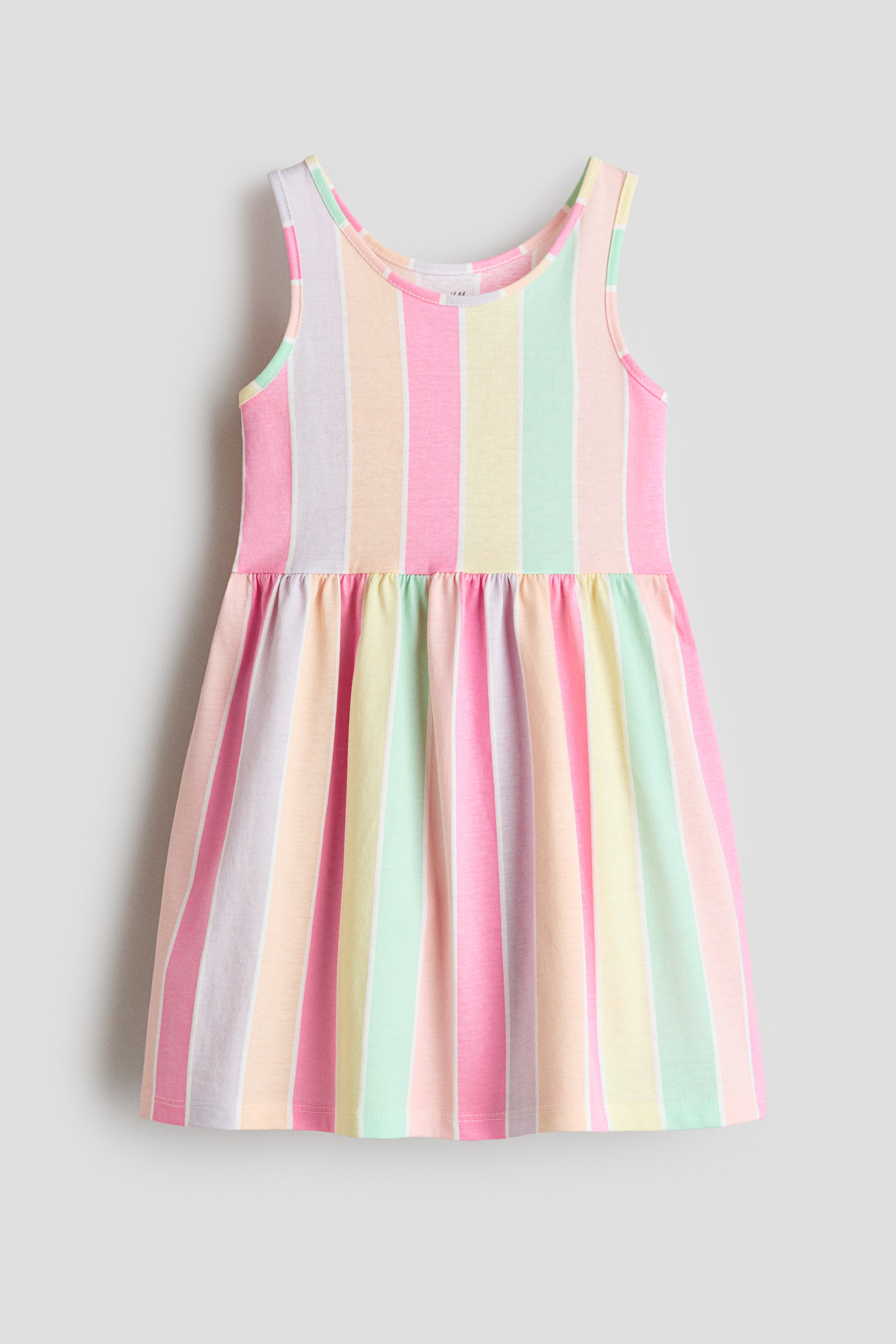 View larger image: "A sleeveless dress is showcased from the front, featuring a pastel multi-coloured vertical stripe pattern on cotton jersey. It displays a gathered seam at the waist and a gently flared skirt."