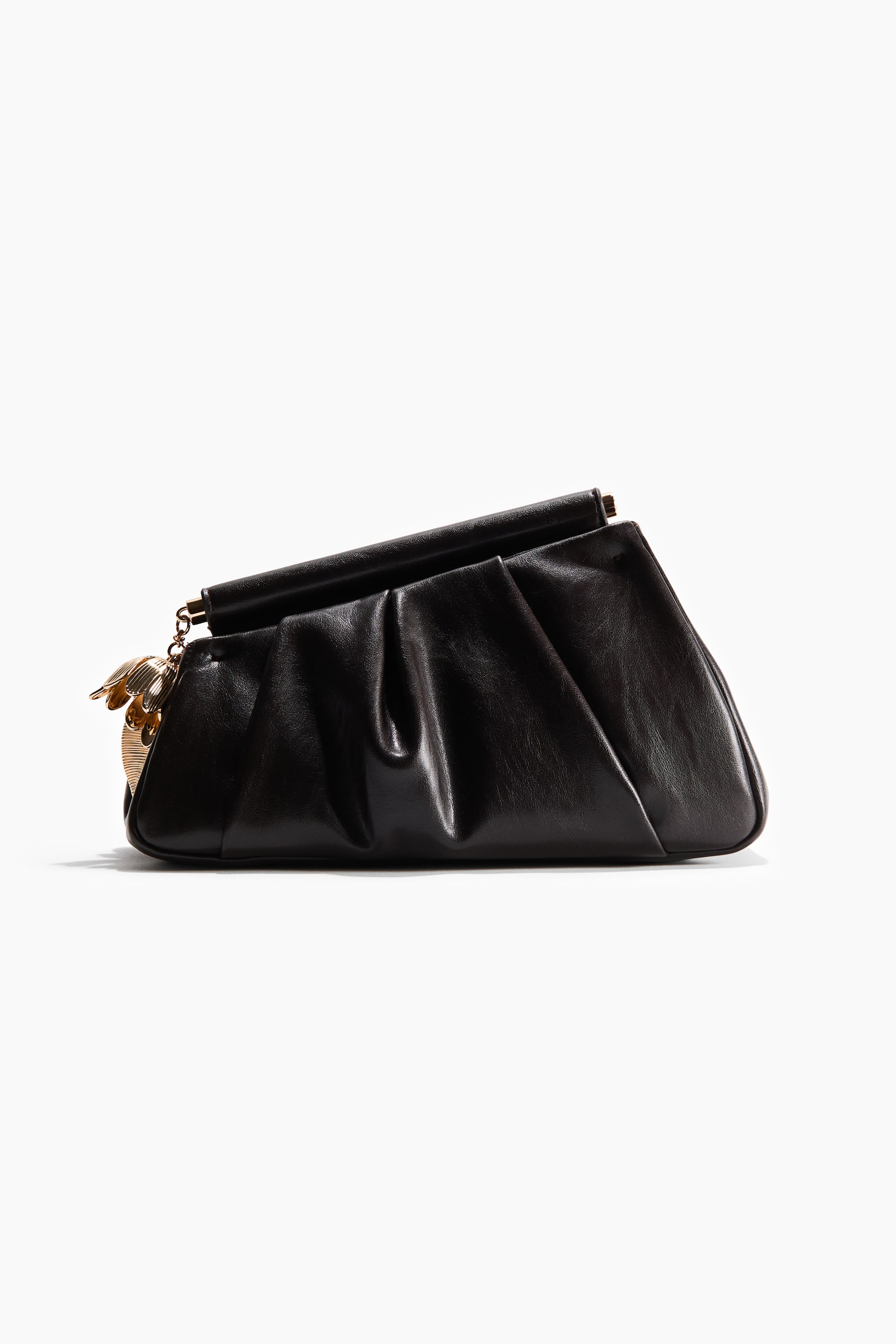 View larger image: A black clutch bag is showcasing its front and right side, highlighting a softly gathered body with a lustrous finish. A gold-toned, sculptural charm is hanging from the left side of its rigid top bar closure.