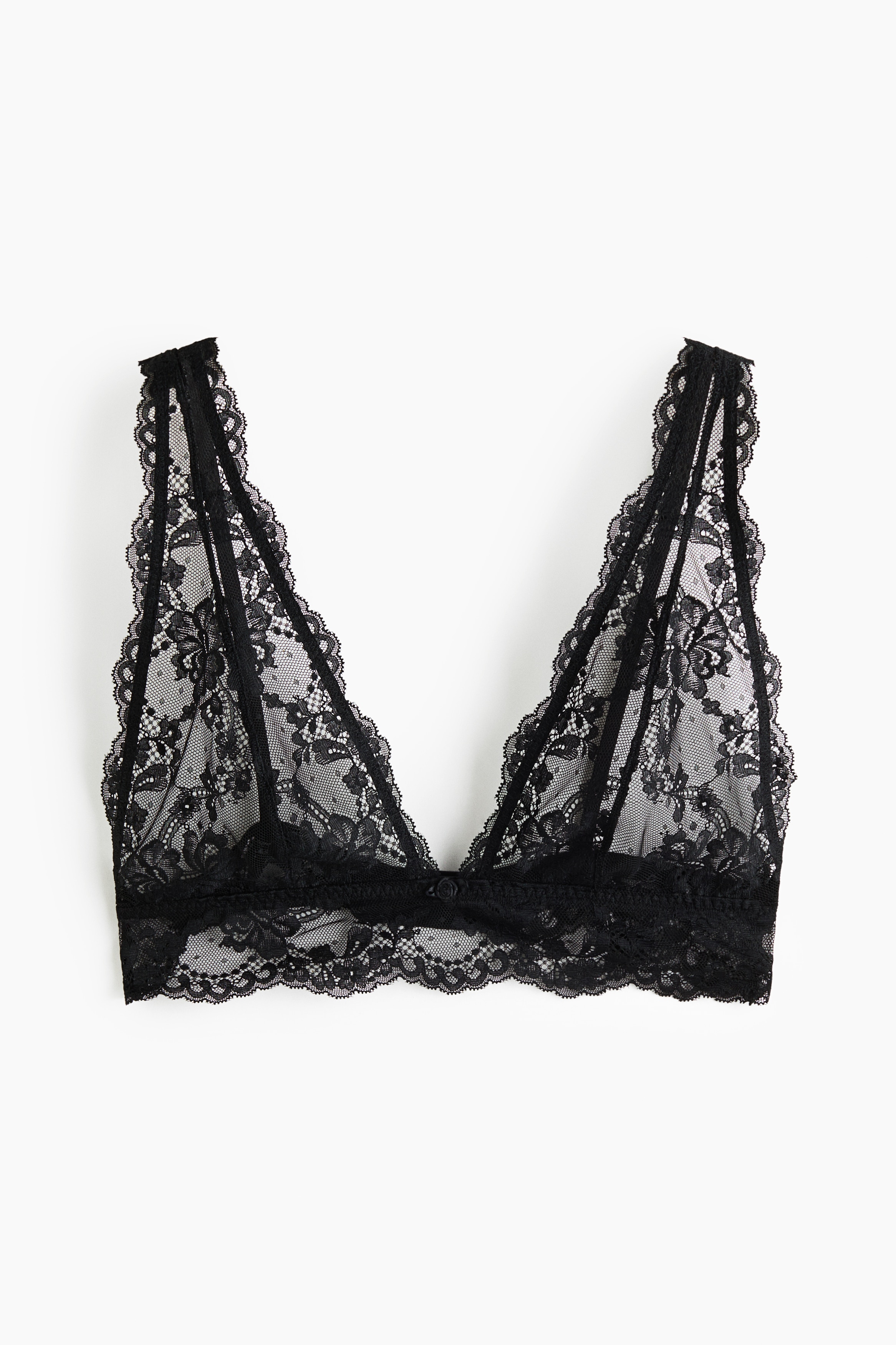 A black lace soft bra featuring sheer triangle cups, wide lace straps, and a scalloped underband is being worn by the model alongside matching black lace briefs.