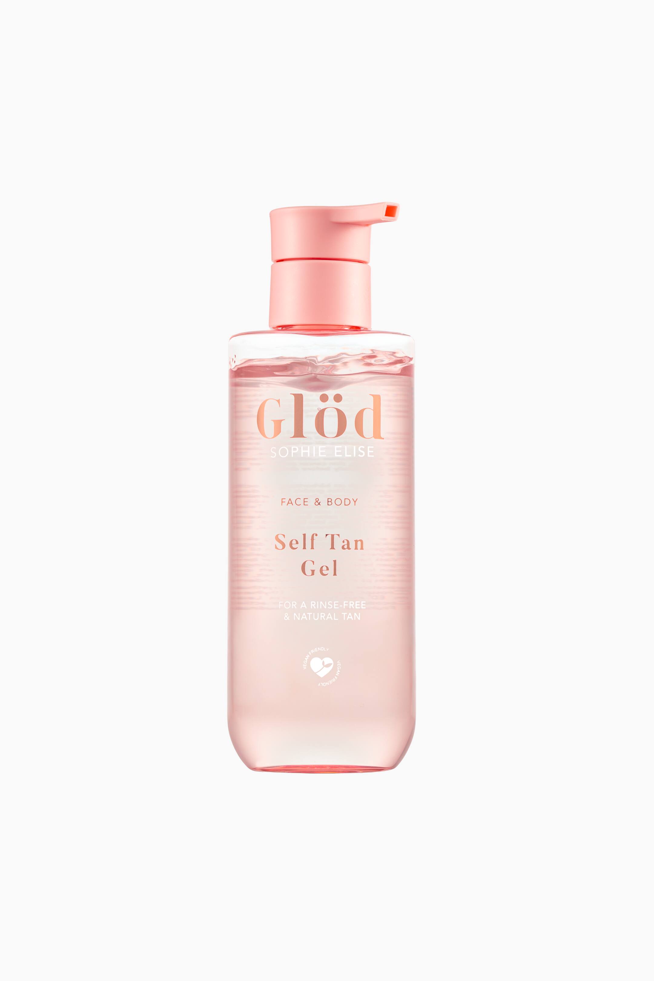 Vis større bilde: En flaske med Glød Sophie Elise Self Tan Gel står oppreist og har en klar, lyserosa tonet sylindrisk flaske som viser den gjennomsiktige gelen inni. Flasken har en matchende pastellrosa pumpedispenser øverst, vendt mot høyre, og har rosegullfarget skrift på forsiden.