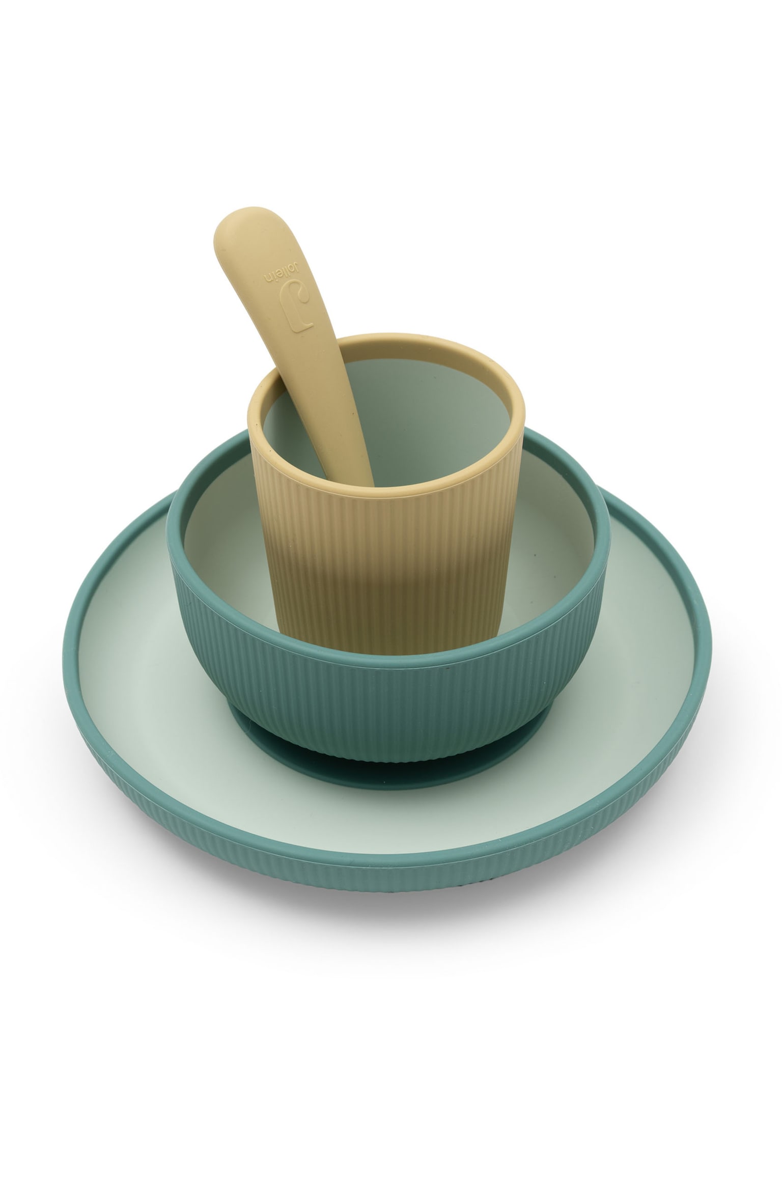 Un service de vaisselle en silicone pour enfants est présenté dans une composition empilée, comprenant une assiette vert canard, un bol vert canard assorti, une tasse beige et une cuillère beige. Lâassiette, le bol et la tasse présentent une texture extérieure côtelée et des intérieurs vert clair contrastants. - 1