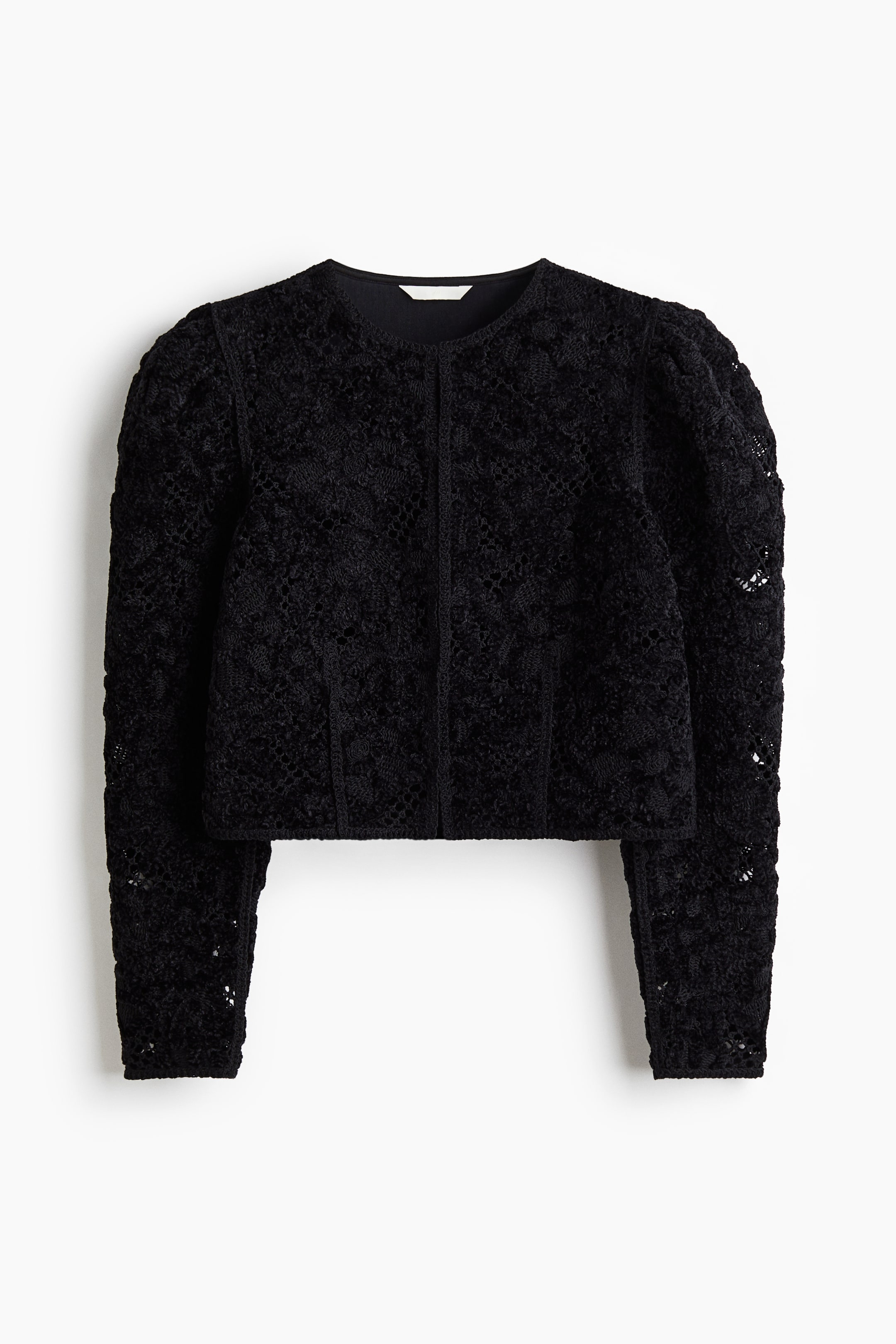 Größeres Bild ansehen: Eine schwarze Spitzenjacke zeigt ihre Vorderseite. Sie verfügt über einen runden, kragenlosen Ausschnitt, gepuffte lange Ärmel und eine verkürzte Länge. Die Jacke besteht aus einem offenen Strick mit floraler Spitze, wobei die Ärmel ungefüttert erscheinen.