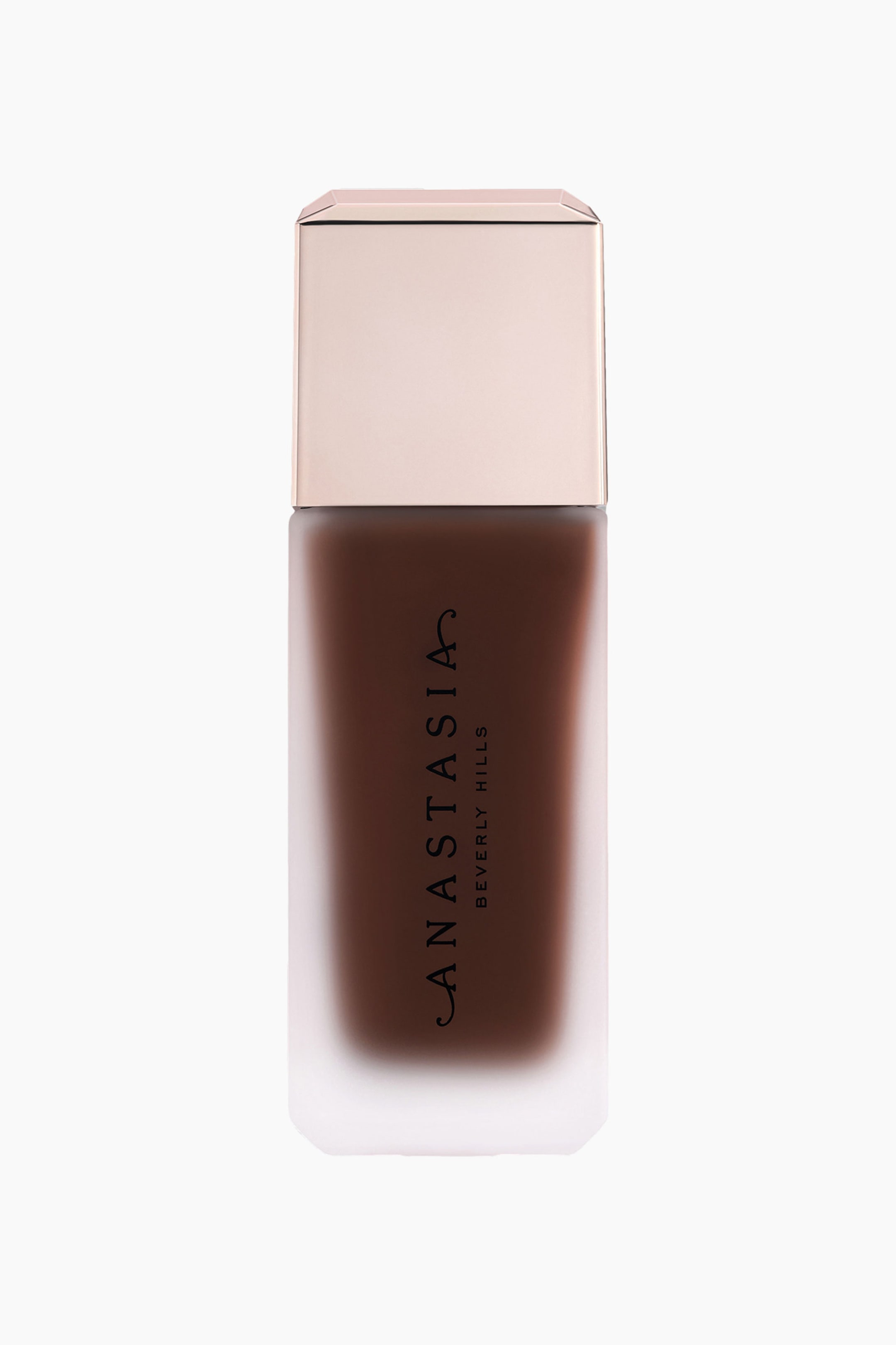 Visa större bild: En rektangulär flaska med mörkbrun flytande foundation står upprätt, med en frostad glas nedre sektion och ett metalliskt roséguld lock. "ANASTASIA BEVERLY HILLS" är vertikalt tryckt i svart på flaskans framsida.