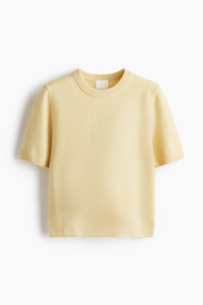 A pale yellow jumper is being presented FRONT. It is featuring a soft, fine knit with a round neckline, short sleeves, and ribbing around the neckline, cuffs, and hem. - 1