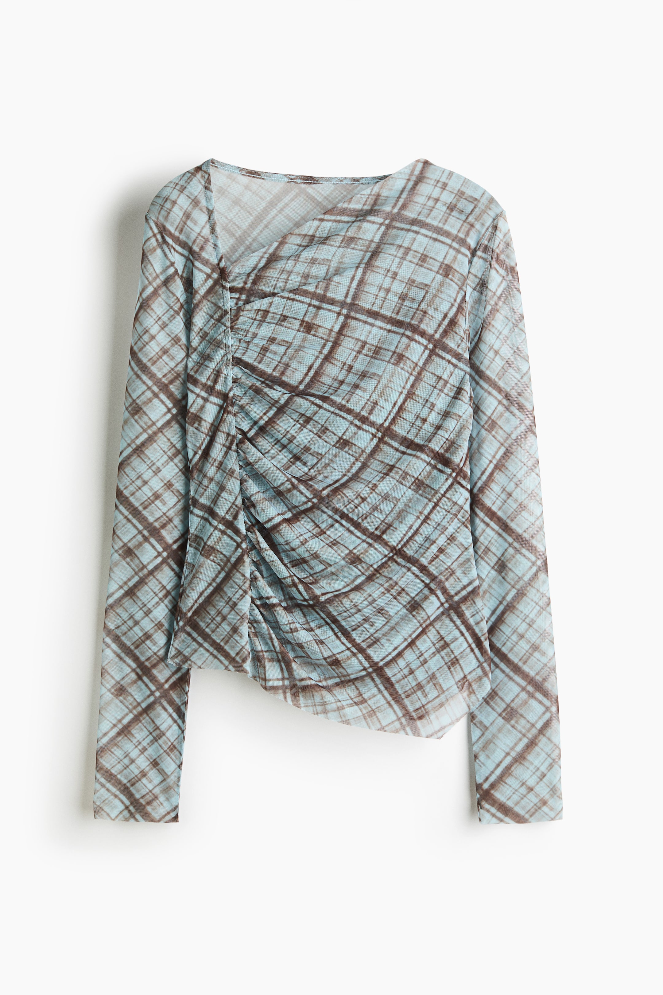 View larger image: A long-sleeved sheer top in a light blue and brown plaid pattern is shown from the front, featuring an asymmetrical neckline and a ruched side seam. The gathered detail creates draped folds across the front of the bodice and an uneven, asymmetrical hemline.